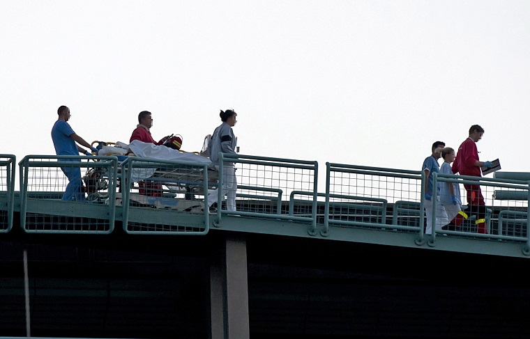 A Hende Csaba honvédelmi miniszter balesetének helyszínéről mentőhelikopterrel Budapestre szállított sérültet tolnak hordágyon a Honvédkórház tetején, 2013. szeptember 19-én.