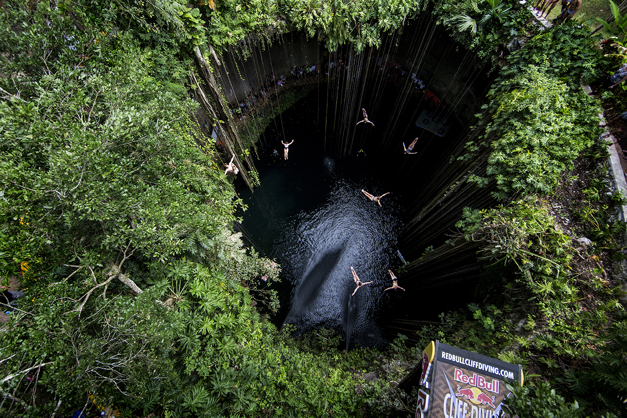 Seven divers perform a mass dive from 19 metres after the second training session of the seventh and final stop of the Red Bull Cliff Diving World Series, Ik Kil cenote, Yucatan, Mexico, on October 16th 2014. // Dean Treml/Red Bull Cliff Diving // P-20141016-00334 // Usage for editorial use only // Please go to www.redbullcontentpool.com for further information. //