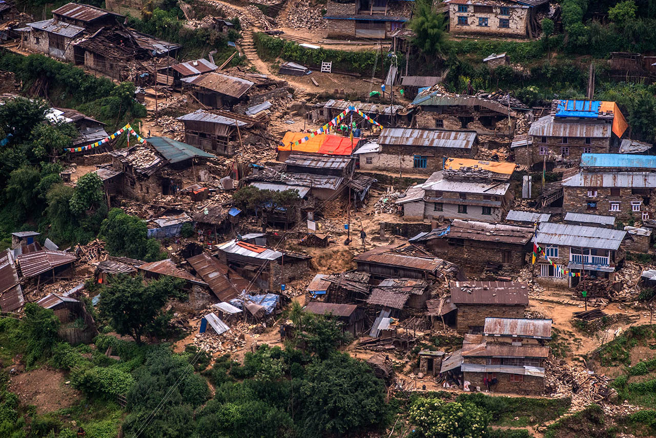 GORKHA, NEPAL - MAY 06:  Damaged houses are seen in a village from an Indian Helicopter on May 6, 2015 near Gorkha, Nepal.  A major 7.9 earthquake hit Kathmandu mid-day on Saturday 25th April, and was followed by multiple aftershocks that triggered avalanches on Mt. Everest that buried mountain climbers in their base camps. Many houses, buildings and temples in the capital were destroyed during the earthquake, leaving over 7000 dead and many more trapped under the debris as emergency rescue workers attempt to clear debris and find survivors. Regular aftershocks have hampered recovery missions as locals, officials and aid workers attempt to recover bodies from the rubble.  (Photo by David Ramos/Getty Images)