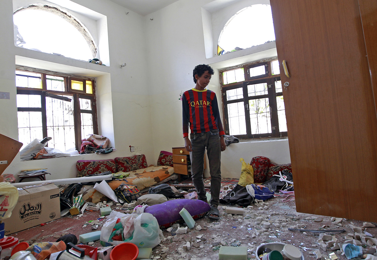 A Yemeni youth stands amid the wreckage inside his house near the residence of ex-President Ali Abdullah Saleh, following reported air strikes on the residence, on May 10, 2015, in the capital Sanaa. Saleh, who stepped down in February 2012 following a year of deadly nationwide protests against his three-decade rule, is accused of siding with Shiite Huthi insurgents who have rebelled against UN-backed President Abedrabbo Mansour Hadi. AFP PHOTO / MOHAMMED HUWAIS