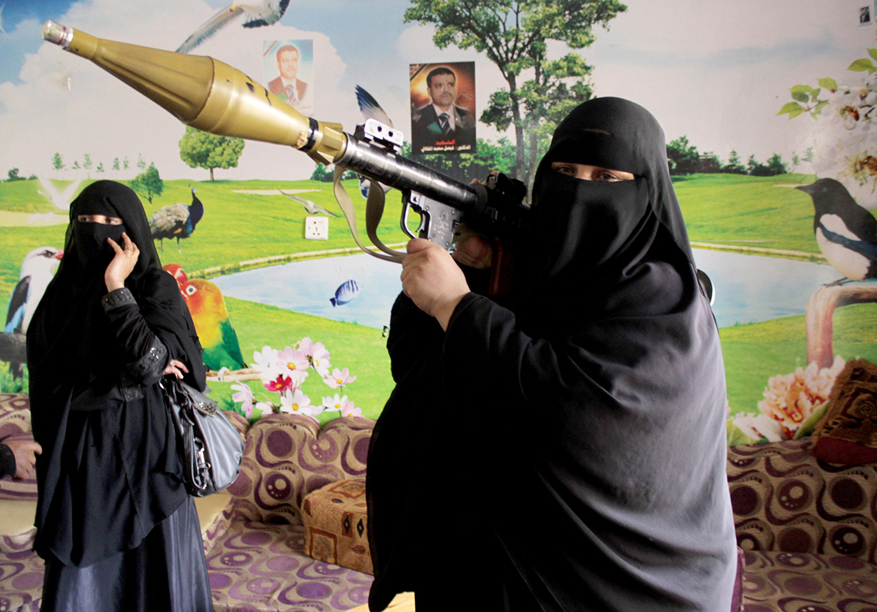 A Yemeni woman, who reportedly asked to join the Popular Resistance Committees loyal to President Abedrabbo Mansour Hadi, poses with a weapon at the home of the Committees' commander Hammud Said al-Mikhlafi (unseen) on May 4, 2015 in the southern city of Taez. Saudi-led air strikes against rebels in Yemen have destroyed much of their military capabilities, but almost six weeks into the campaign the situation on the ground remains unchanged, analysts said.  AFP PHOTO / ABDEL RAHMAN ABDALLAH