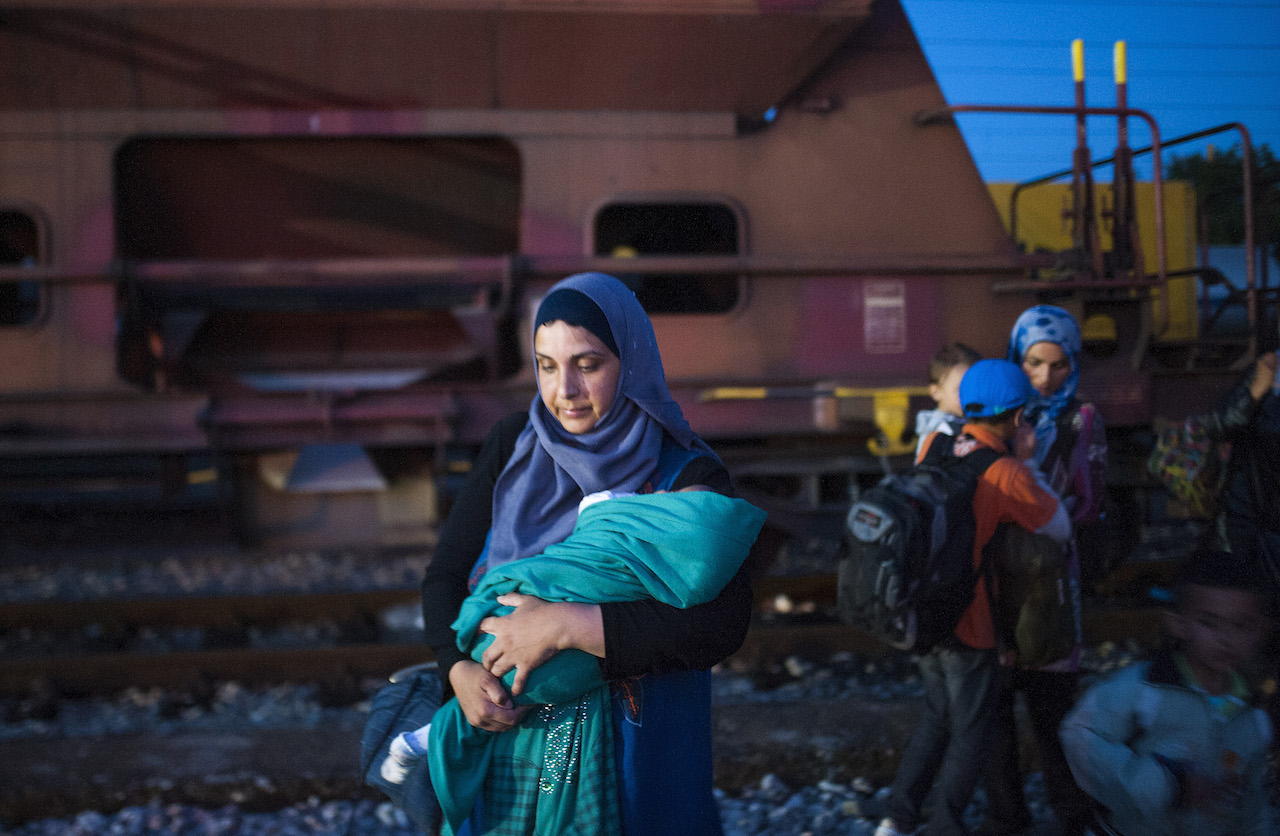 TOPSHOTS Migrants arrive at a Macedonian railway station in Gevgelija on August 22, 2015. More than 1,500 mostly Syrian refugees, trapped in a no-man's land for three days, entered Macedonia from Greece, after police allowed them to pass despite earlier trying to hold back the crowd using stun grenades. AFP PHOTO/ ROBERT ATANASOVSKI