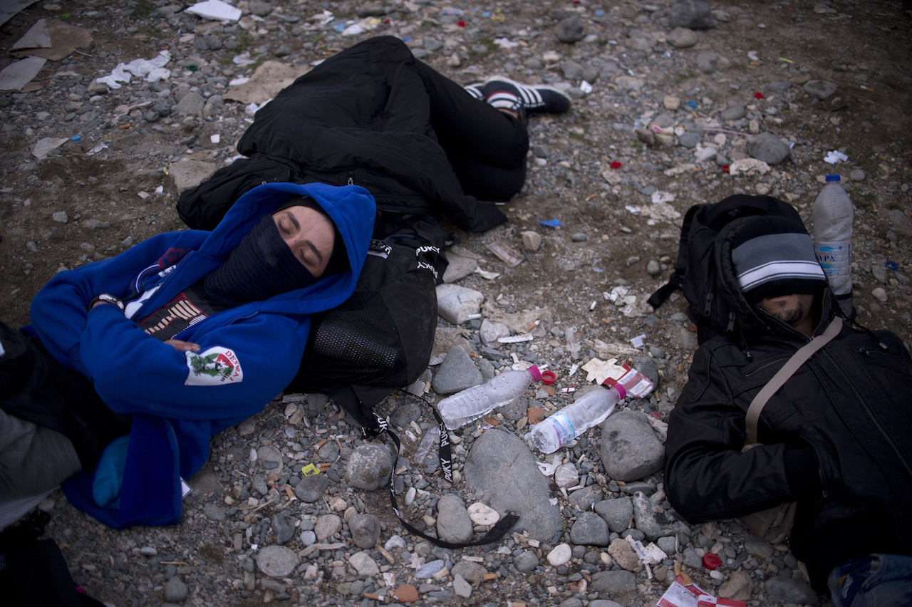 Migrants sleep on the ground in a register camp after crossing the Macedonian-Greek border near Gevgelija on September 24, 2015. EU ministers neared a compromise on plans to relocate 120,000 refugees at emergency talks despite deep divisions over how to handle Europe's worst migration crisis since World War II.      AFP PHOTO / NIKOLAY DOYCHINOV