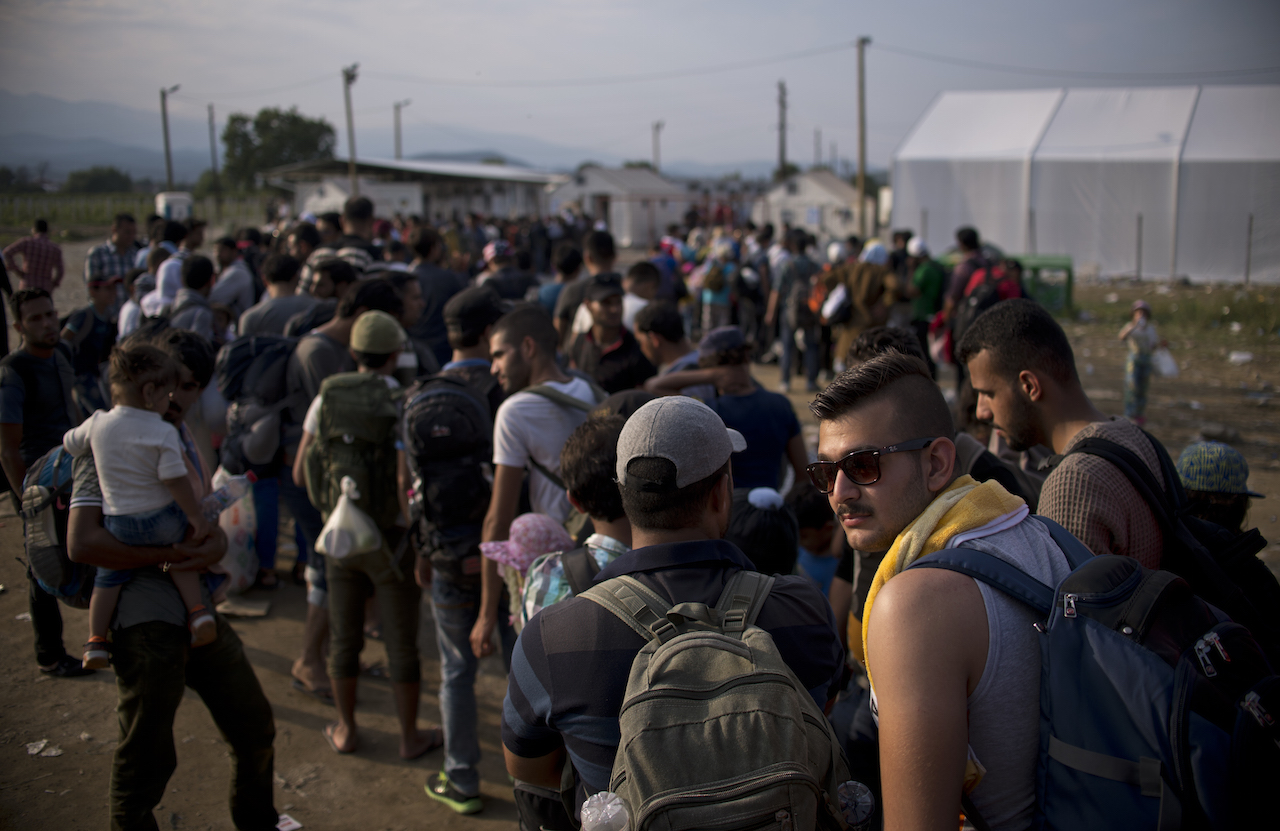 Migrants queue to be registered at a camp after crossing the Macedonian-Greek border near Gevgelija on September 23, 2015. European Union leaders hold an emergency migration summit on September 23 amid a growing east-west split after ministers forced through a controversial deal to relocate 120,000 refugees. AFP PHOTO / NIKOLAY DOYCHINOV