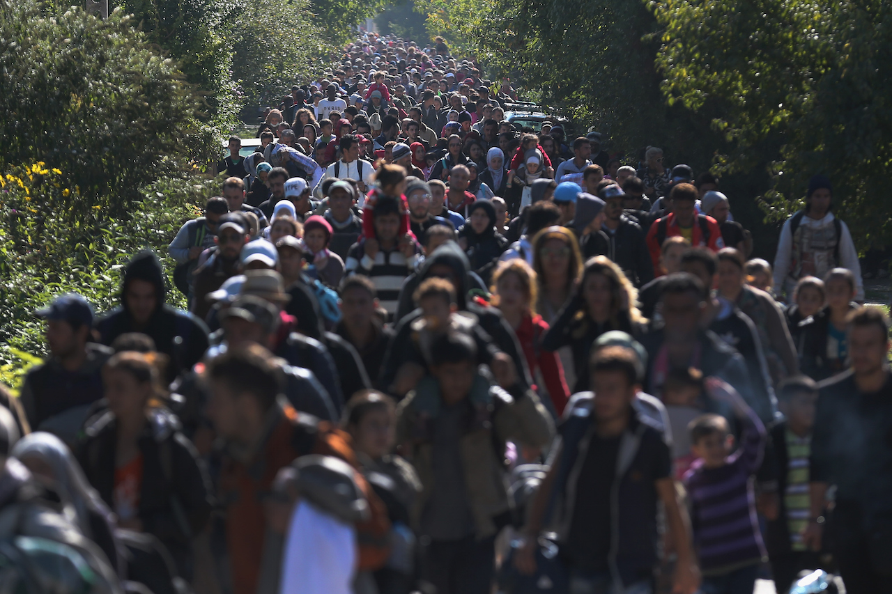 HEGYESHALOM, HUNGARY - SEPTEMBER 22:  Hundreds of migrants who arrived by train at Hegyeshalom on the Hungarian and Austrian border walk the four kilometres into Austria on September 22, 2015 in Hegyeshalom, Hungary. Thousands of migrants have arrived in Austria over the weekend with more en-route from Hungary, Croatia and Slovenia. Politicians across the European Union are holding meetings on the refugee crisis with EU leaders attending an extraordinary summit on Wednesday to try and solve the crisis and the dispute of how to relocate 120,000 migrants aross EU states.  (Photo by Christopher Furlong/Getty Images)