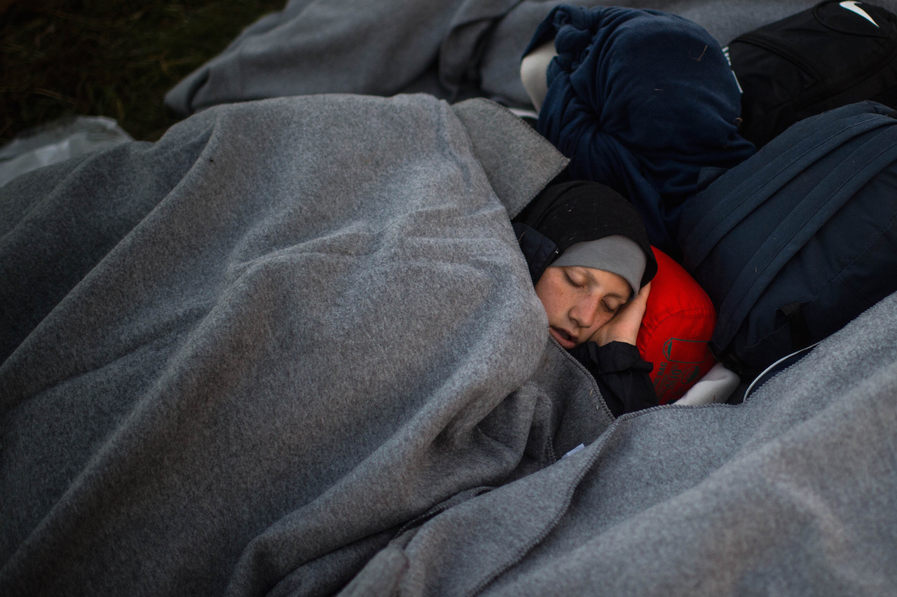 OPATOVAC, CROATIA - SEPTEMBER 23:  Migant wait outside a refugee camp early in the morning as more arrive from the Serbian border on September 23, 2015 in Opatovac, Croatia. Croatia has built a refugee camp to control the transit of migrants to Hungary with a capacity of 4,000 people. Thousands of migrants have arrived in Austria over the weekend with more en-route from Hungary, Croatia and Slovenia. Politicians across the European Union are to hold meetings on the refugee crisis with EU interior ministers meeting tomorrow and EU leaders attending an extraordinary summit on Wednesday.  (Photo by David Ramos/Getty Images)