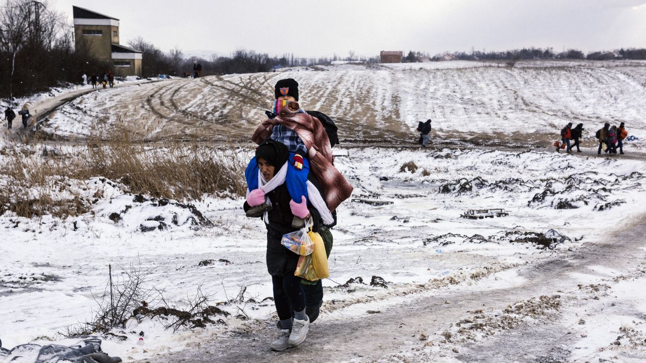 Menekült nő cipeli a gyerekét a hóban, a szerb-észak-macedón határon, 2016