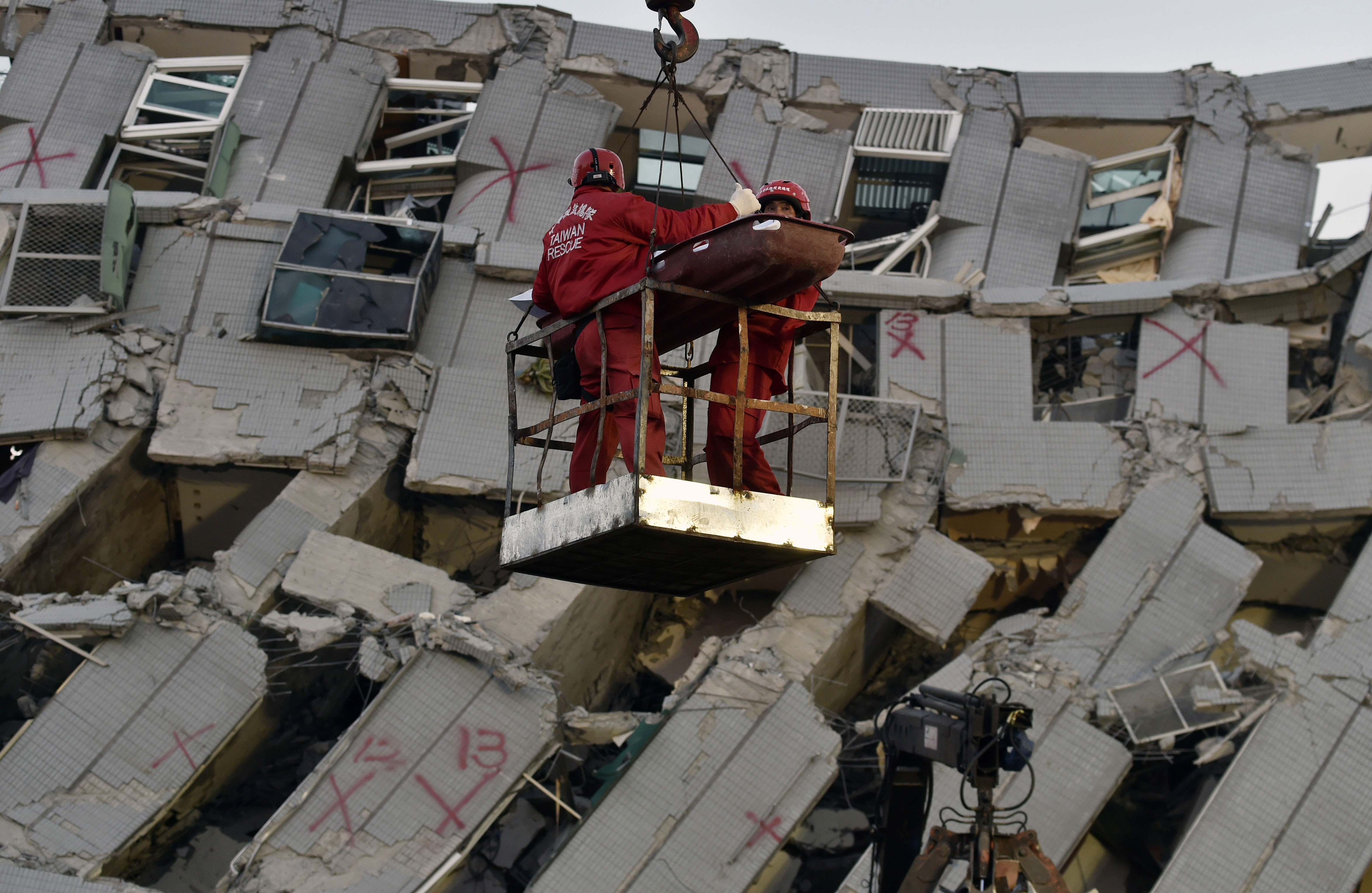 Túlélők után kutatnak a földrengésben összeomlott lakóházak romjai között Tajvanon