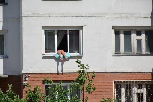 Botrány a Kropotkin utcában: elegük lett a szomszédoknak a félpucéran, ablakon kilógva napozó nőből 