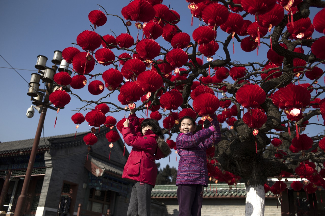 Fotóhoz pózoló gyerekek Pekingben. AFP PHOTO / FRED DUFOUR