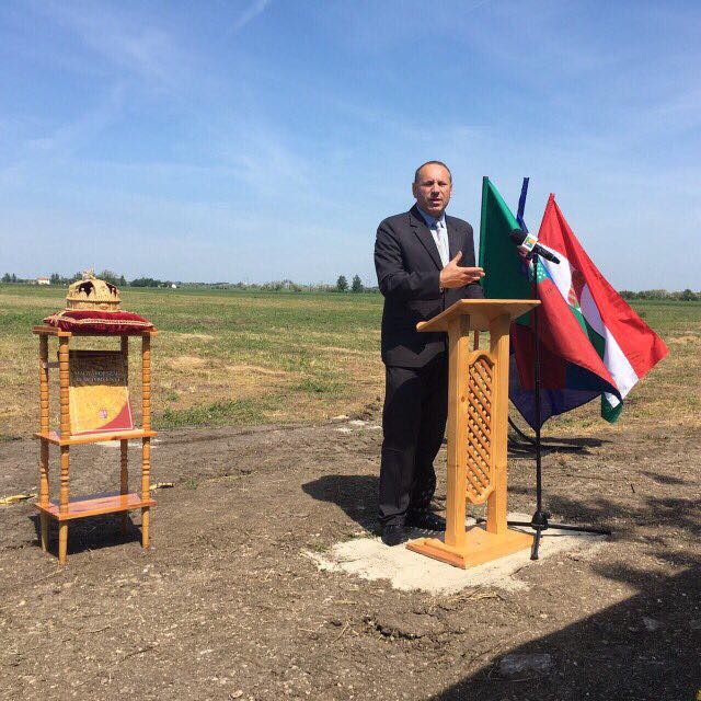 Boldog István fideszes képviselő a Szent Korona utánzata és az Alaptörvény előtt lerakja a tiszatenyői baromfivágóhíd alapkövét 2017. május 18-án.