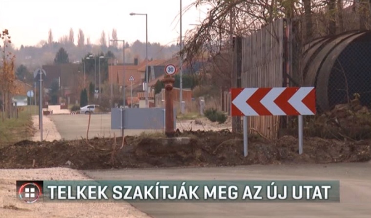 Pilisvörösvár épített egy utat, de két telektulajdonos nem akar átadni 15 métert az önkormányzatnak, így két helyen is kerítés szakítja meg az aszfaltcsíkot