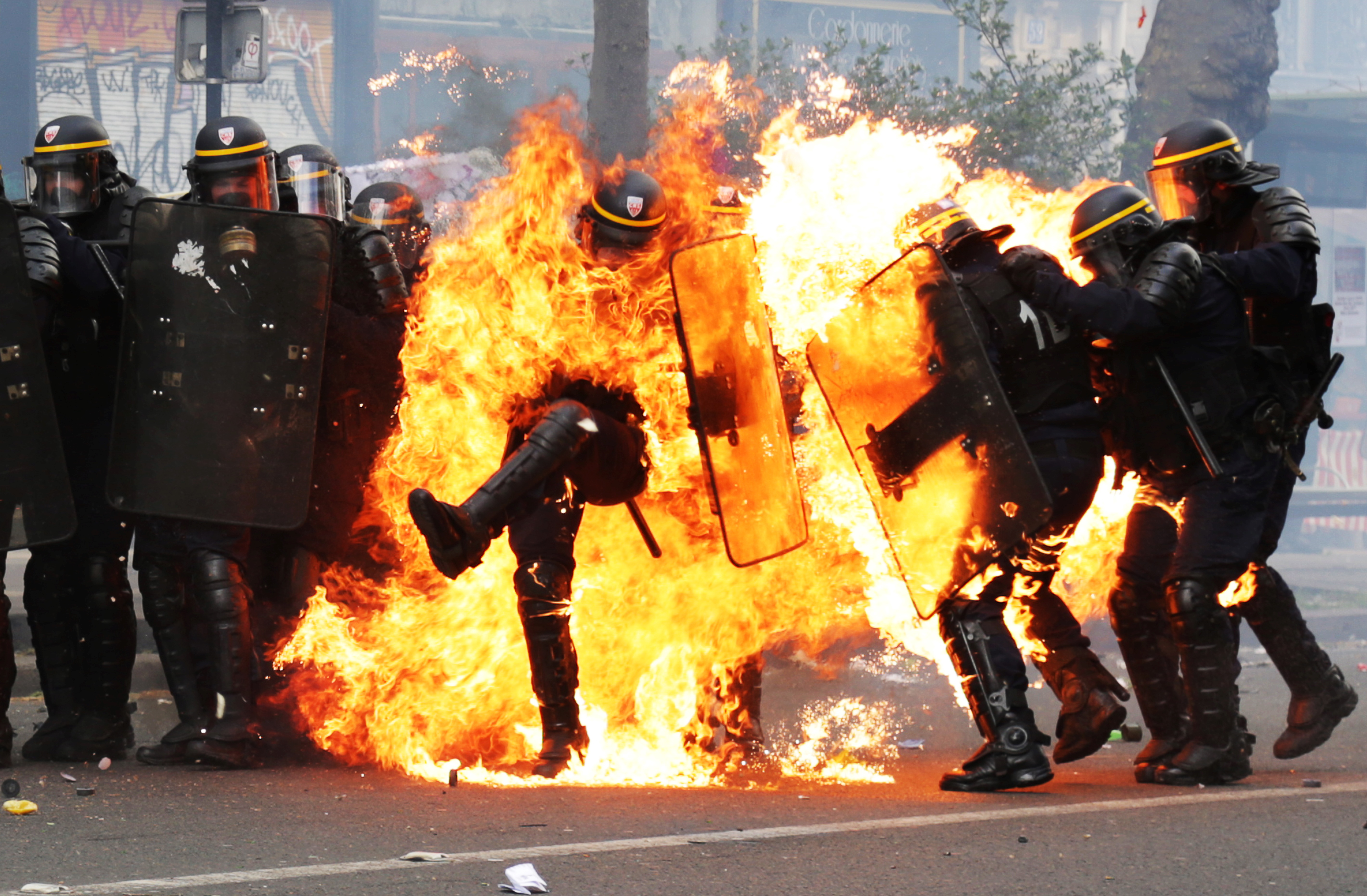 French CRS anti-riot police officers are engulfed in flames as they face protesters during a march for the annual May Day workers' rally in Paris on May 1, 2017