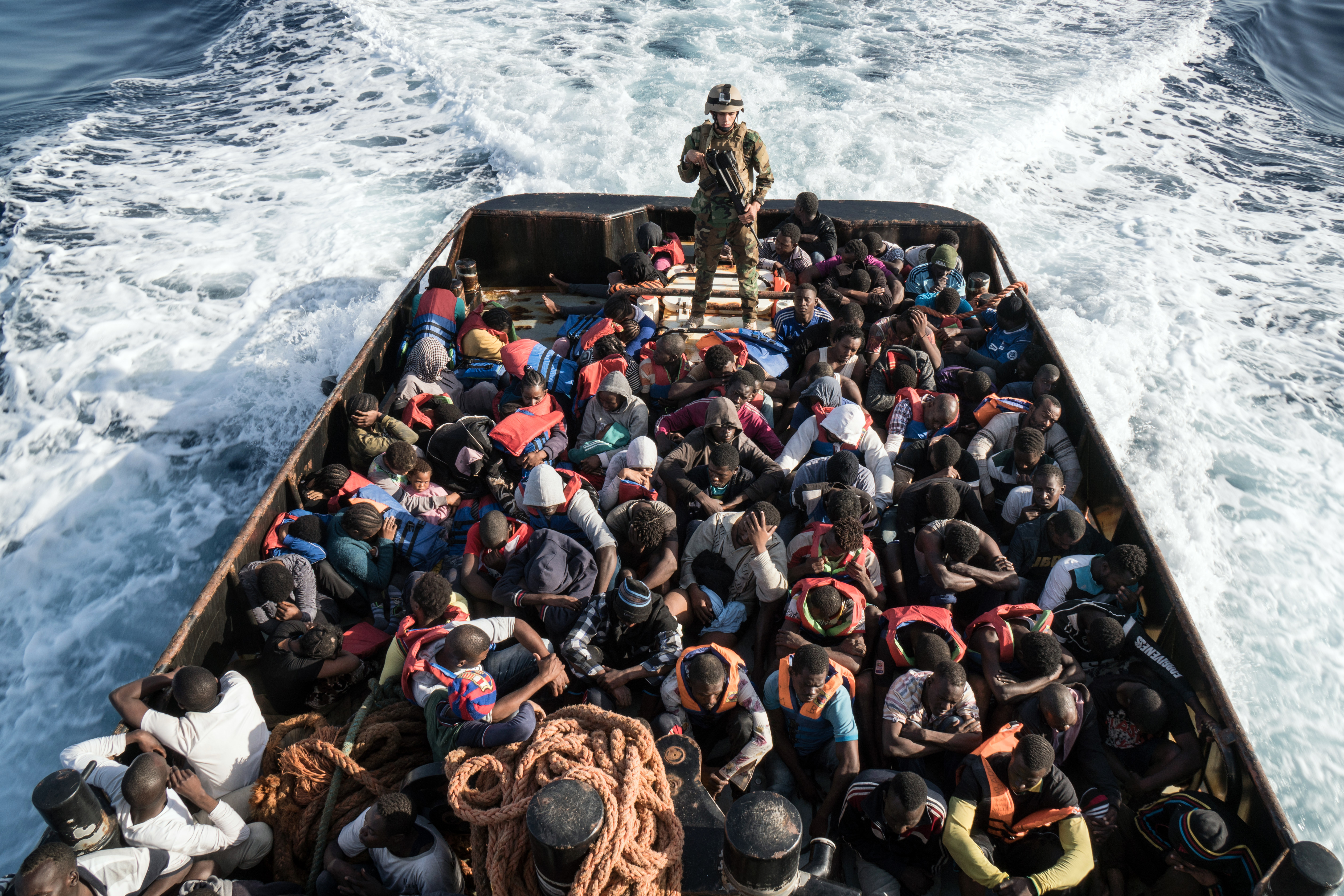 A Libyan coast guardsman stands on a boat during the rescue of 147 illegal immigrants attempting to reach Europe off the coastal town of Zawiyah, 45 kilometres west of the capital Tripoli, on June 27, 2017..More than 8,000 migrants have been rescued in waters off Libya during the past 48 hours in difficult weather conditions, Italy's coastguard said on June