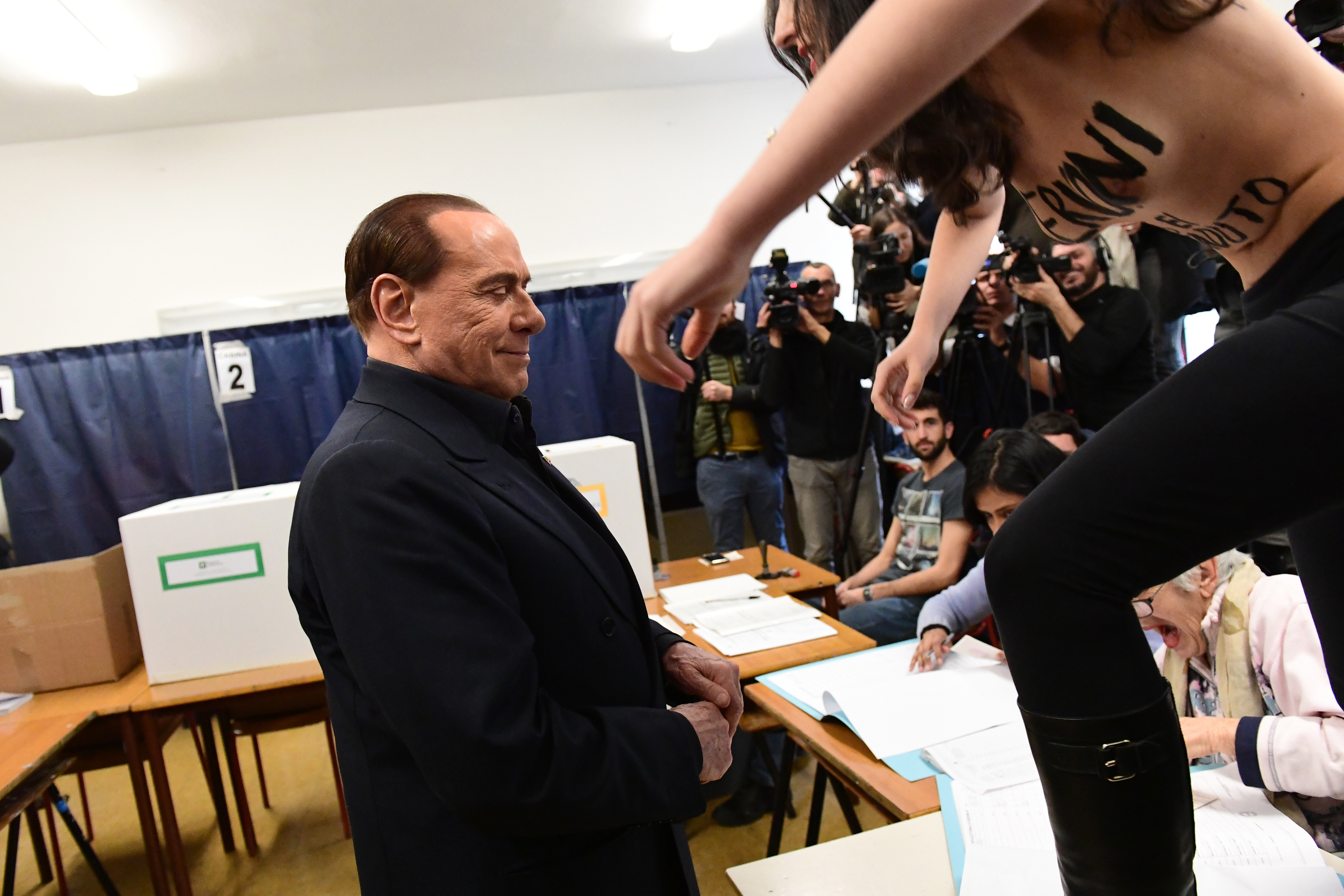Félmeztelen aktivista rohanta le Berlusconit, aki gyorsan menekülőre fogta