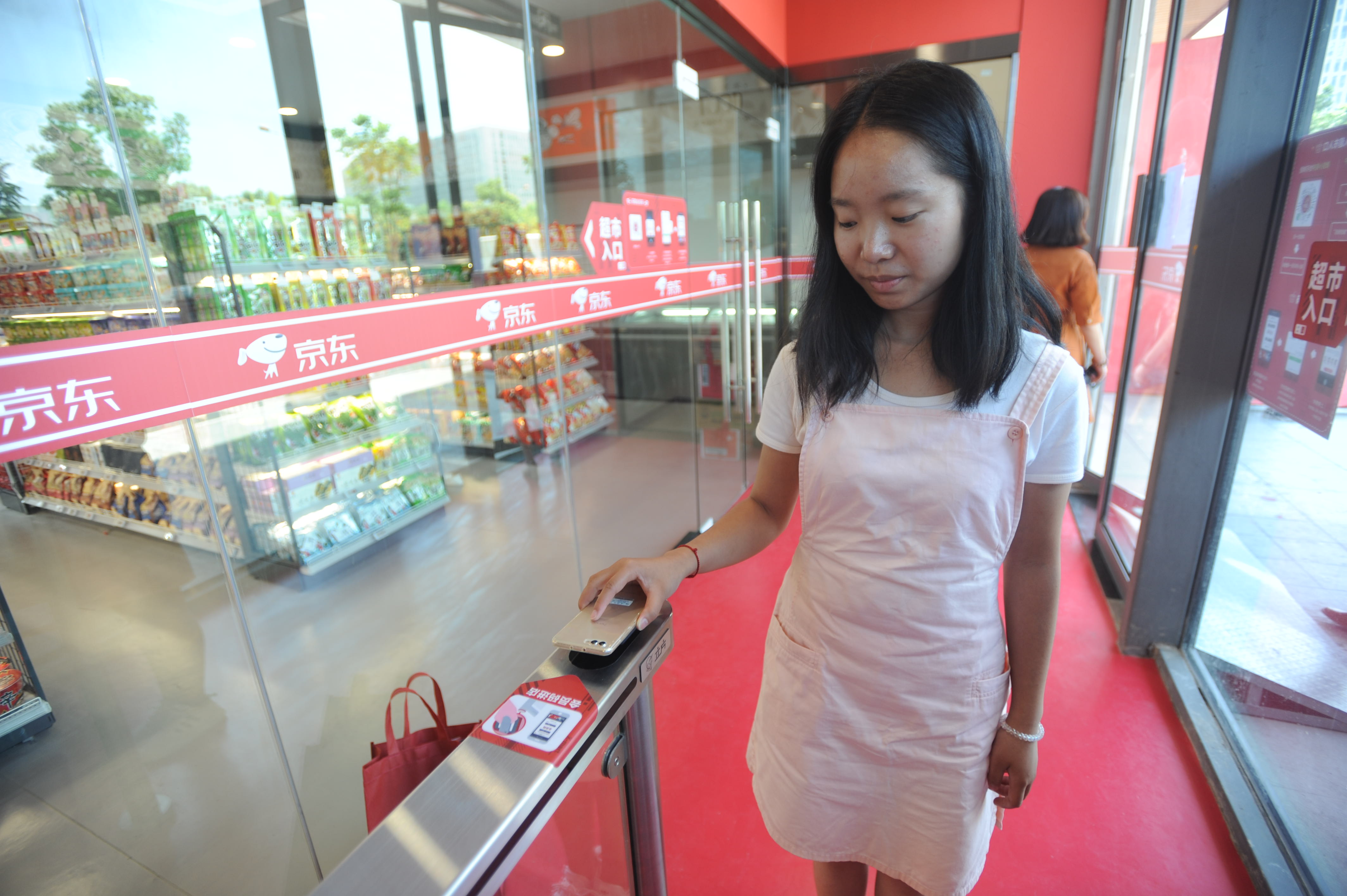 Vásárlás WeChattel Kínában: a vásárló a boltba lépéskor készít magáról egy szelfit, onnantól minden automatikusan történik az áruk összeválogatásától a fizetésig, eladók és kassza nélkül.