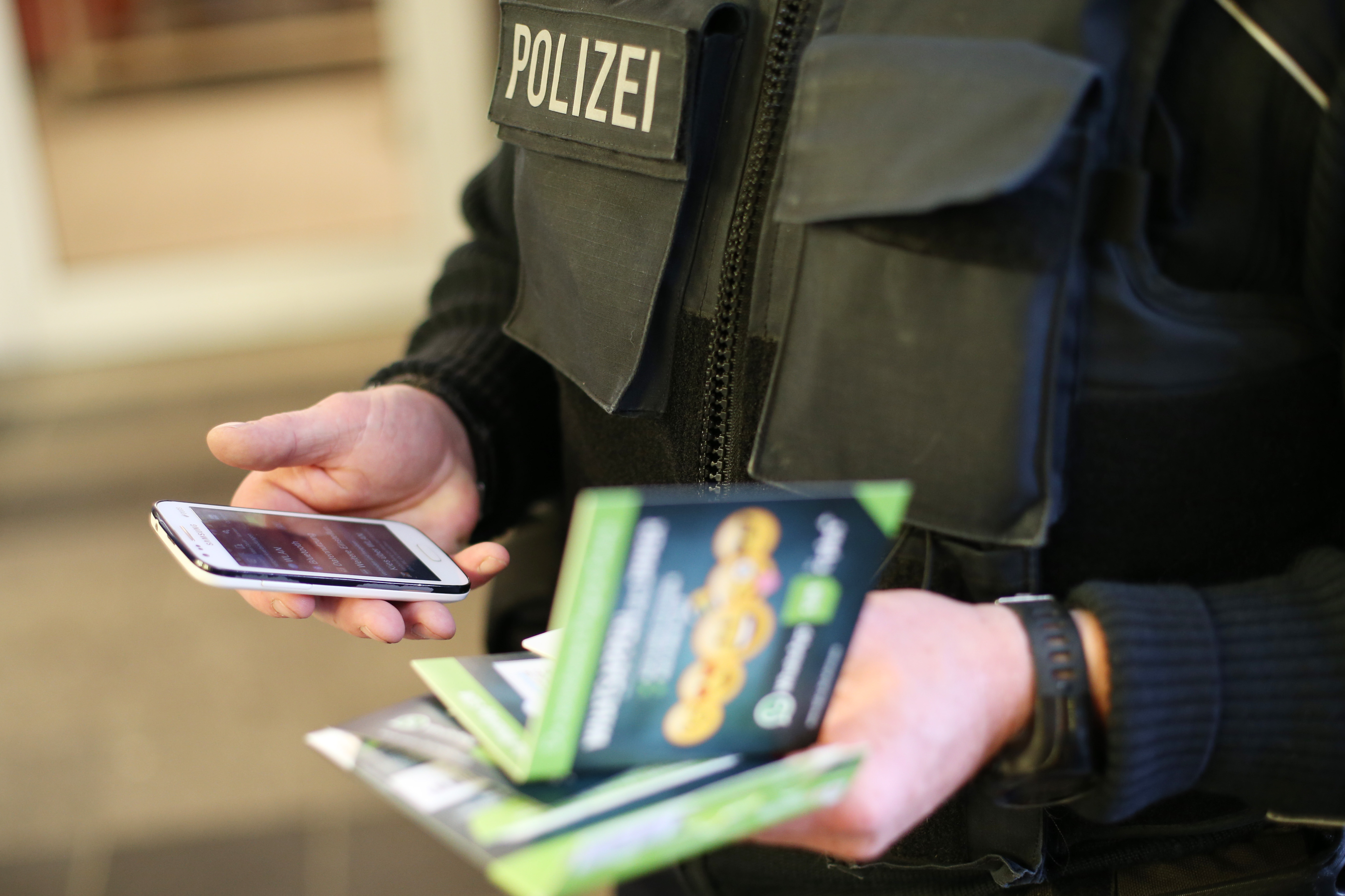 Német rendőr egy Dániába továbbutazó menekült mobil-előfizetését intézi