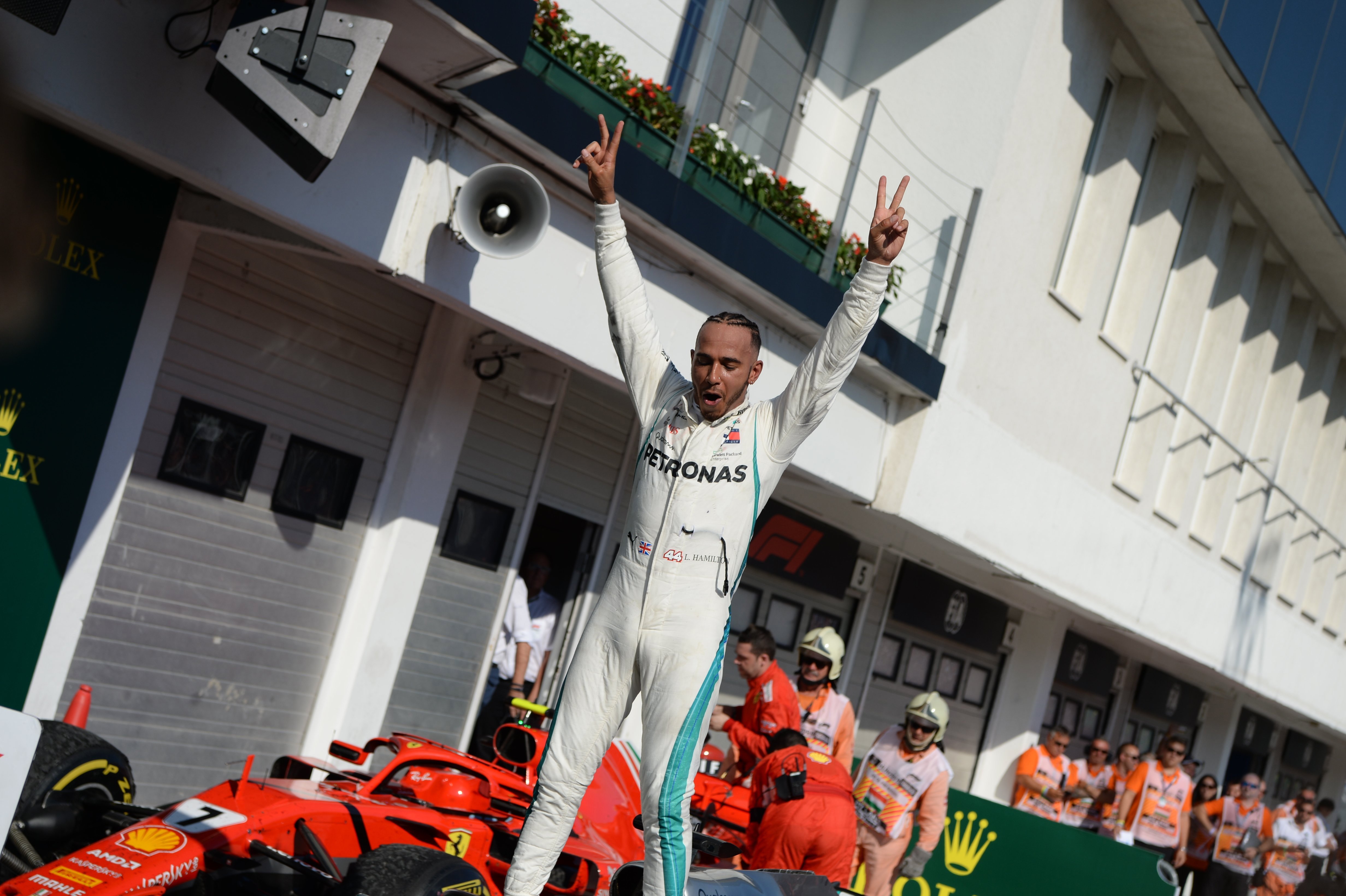 Lewis Hamilton győztesként a 2018-as Magyar Nagydíjon, mögötte pedig leendő csapatának autója.