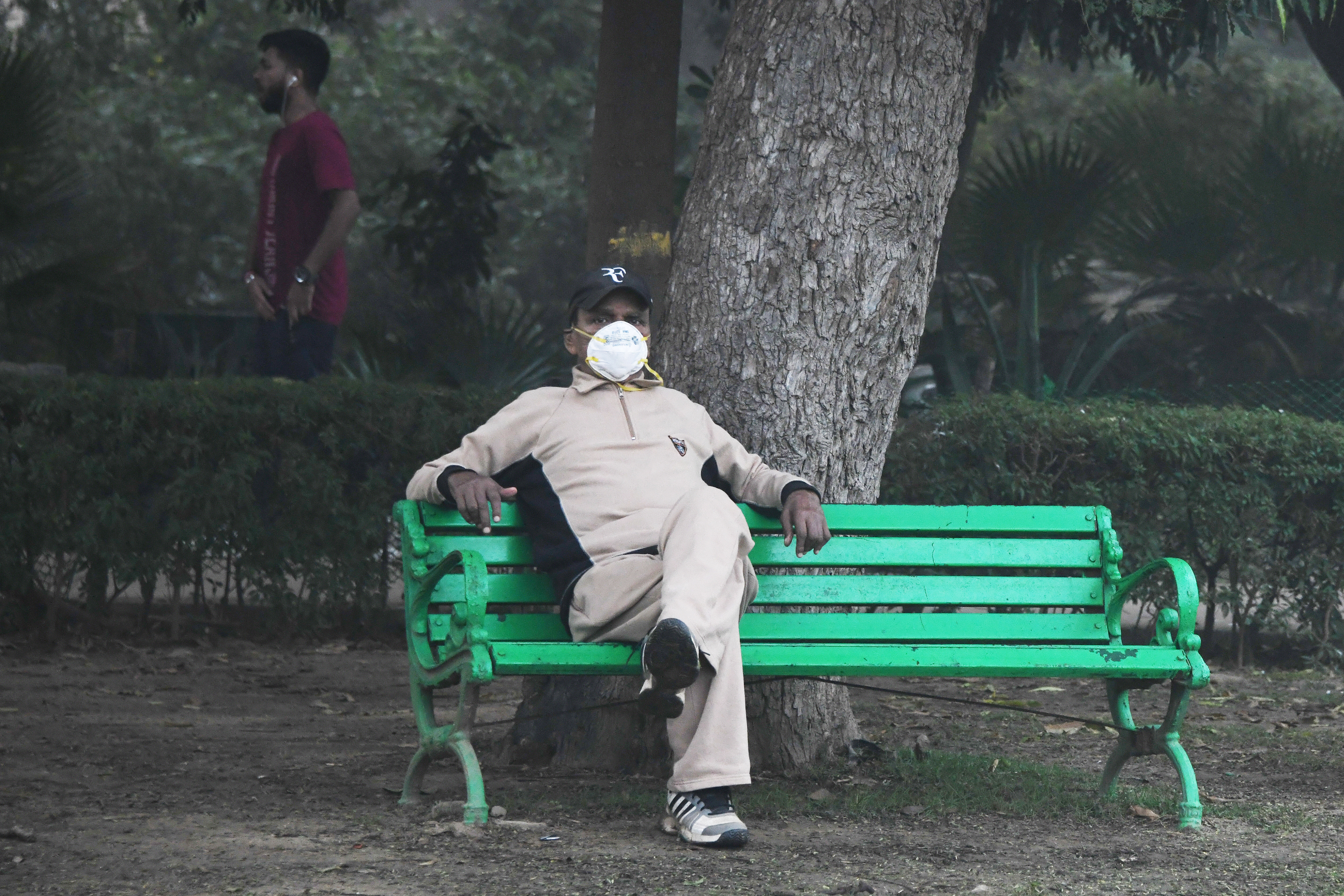 Séta a parkban: egy maszkos férfi Új-Delhiben