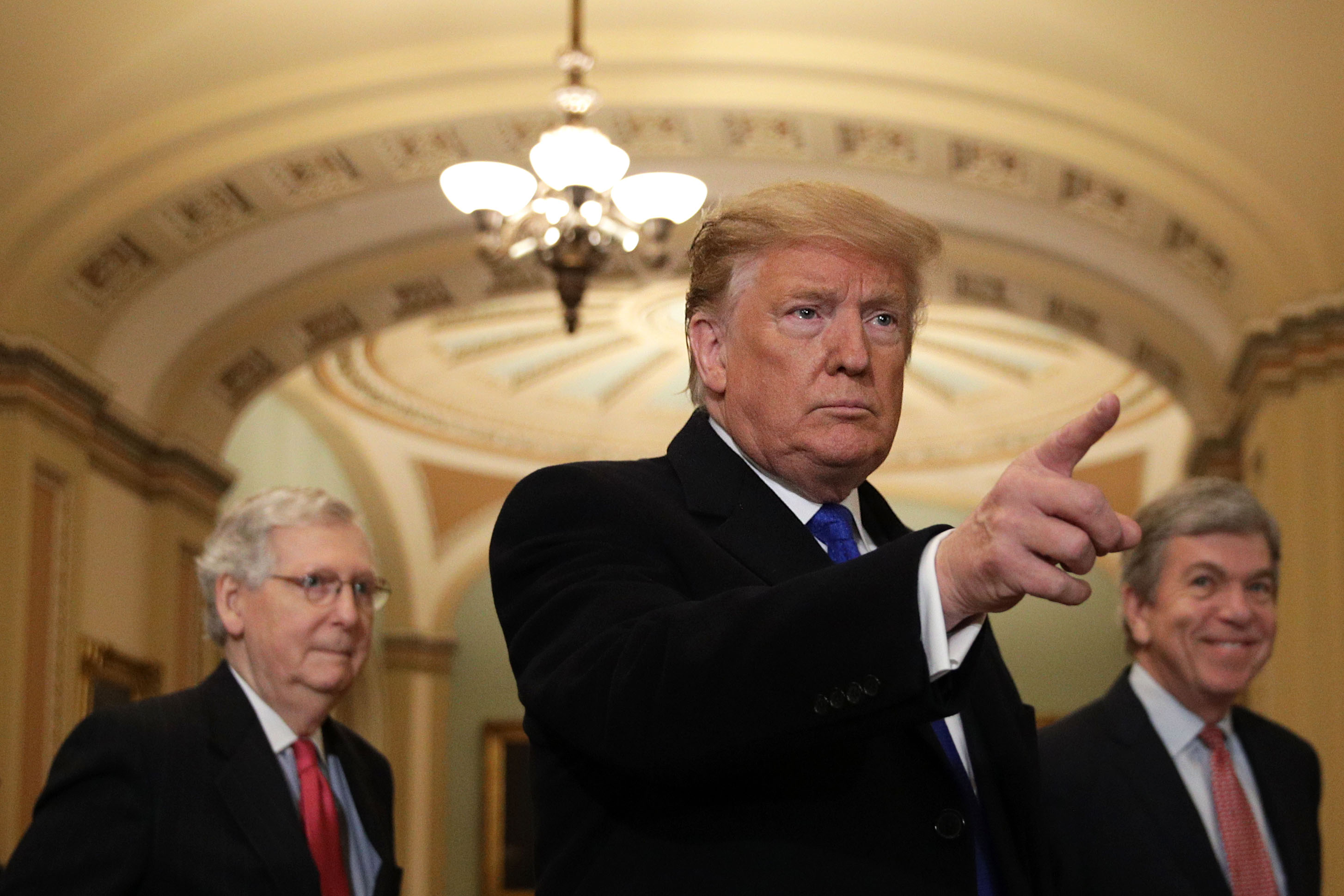 Donald Trump 2019. március 26-án, már William Barr rövid összefoglalójának nyilvánosságra hozatala után az amerikai törvényhozás épületében, a háttérben Mitch McConnell (b.) és Roy Blunt (j.) republikánus szenátorokkal.