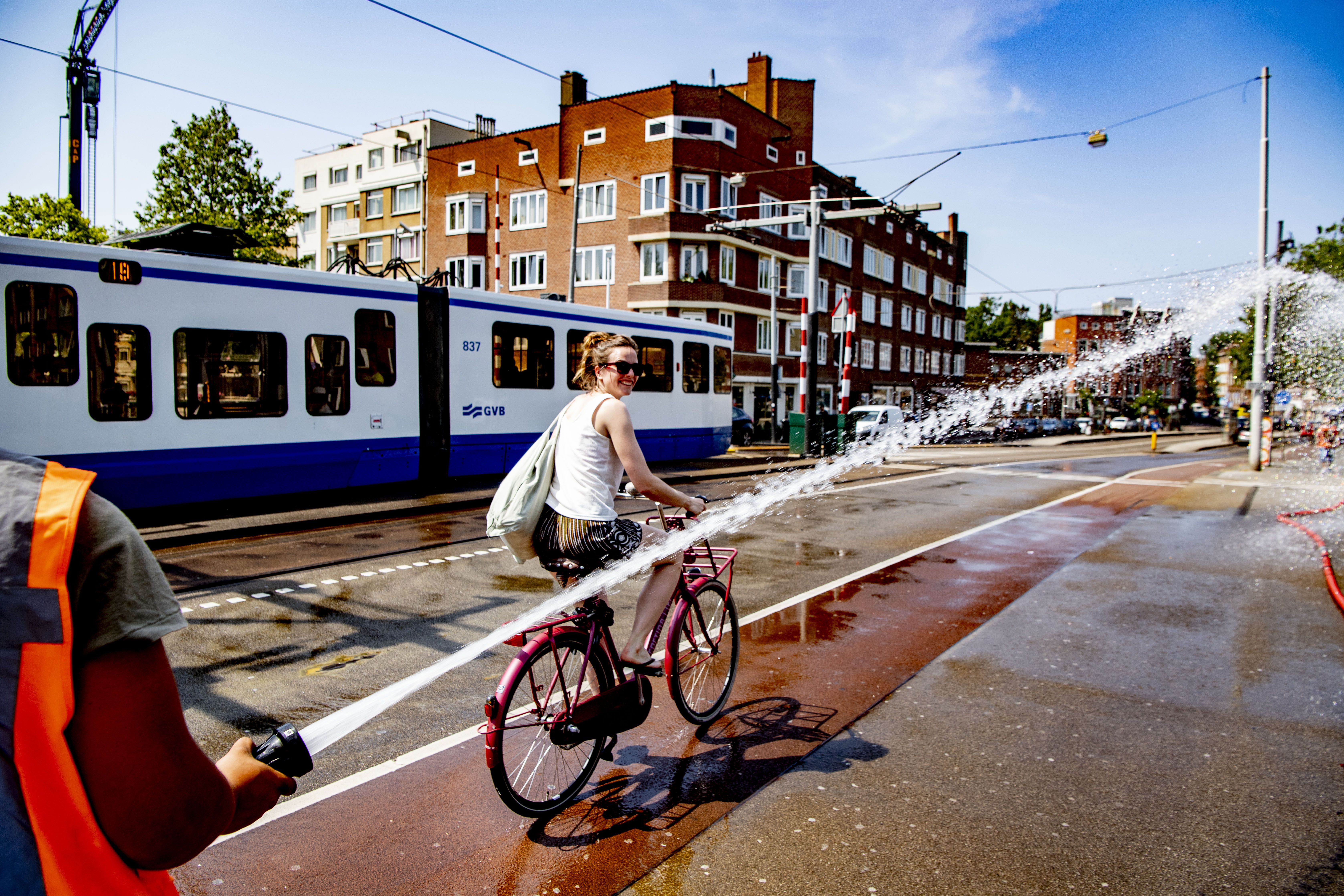 Amszterdamban a tűzoltók hűtik az utakat, a biciklisták nagy örömére