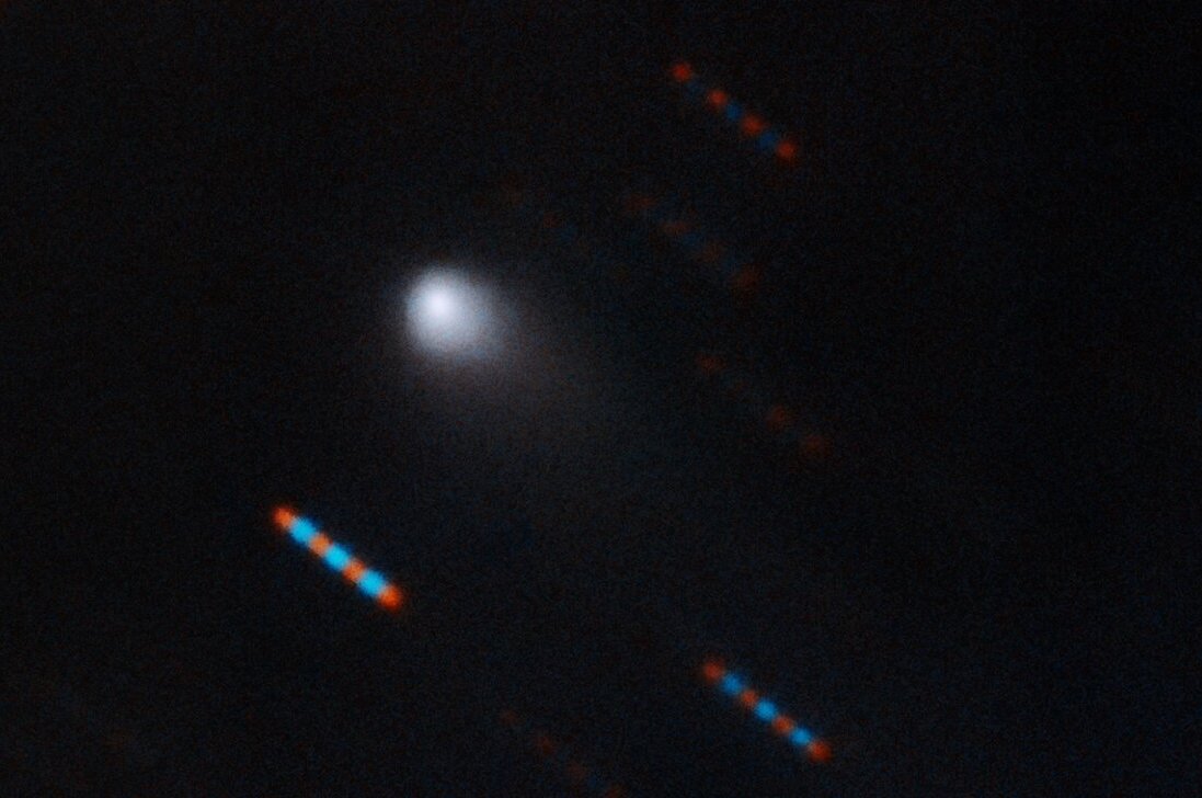A Hawaii-on található Gemini obszervatórium felvétele az I2/Borisov csillagközi üstökösről. A képen látható színes csíkok távoli csillagok.