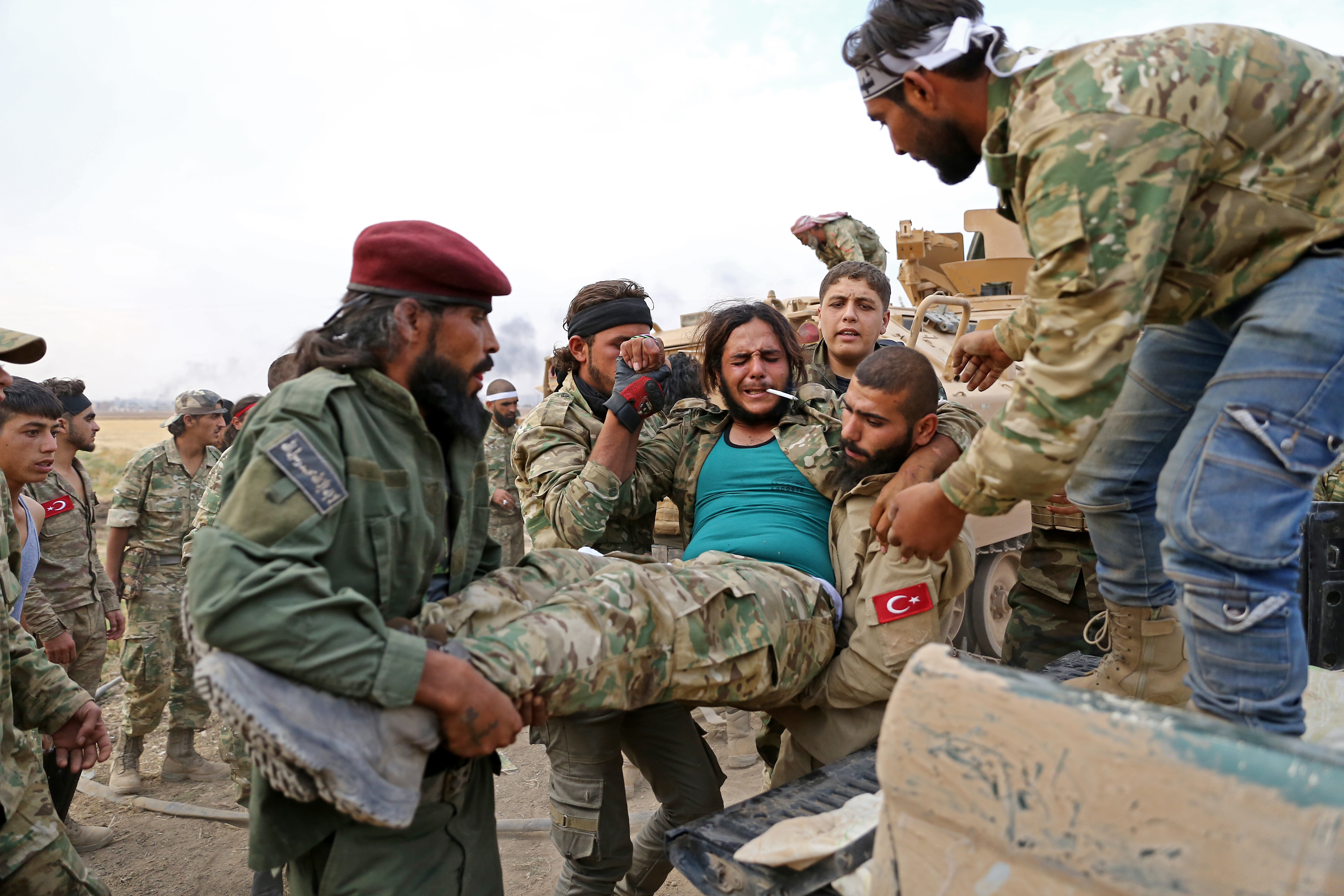 Törökbarát szír fegyveresek egy sebesült társukat szállítják el Ras al-Ainnál.
