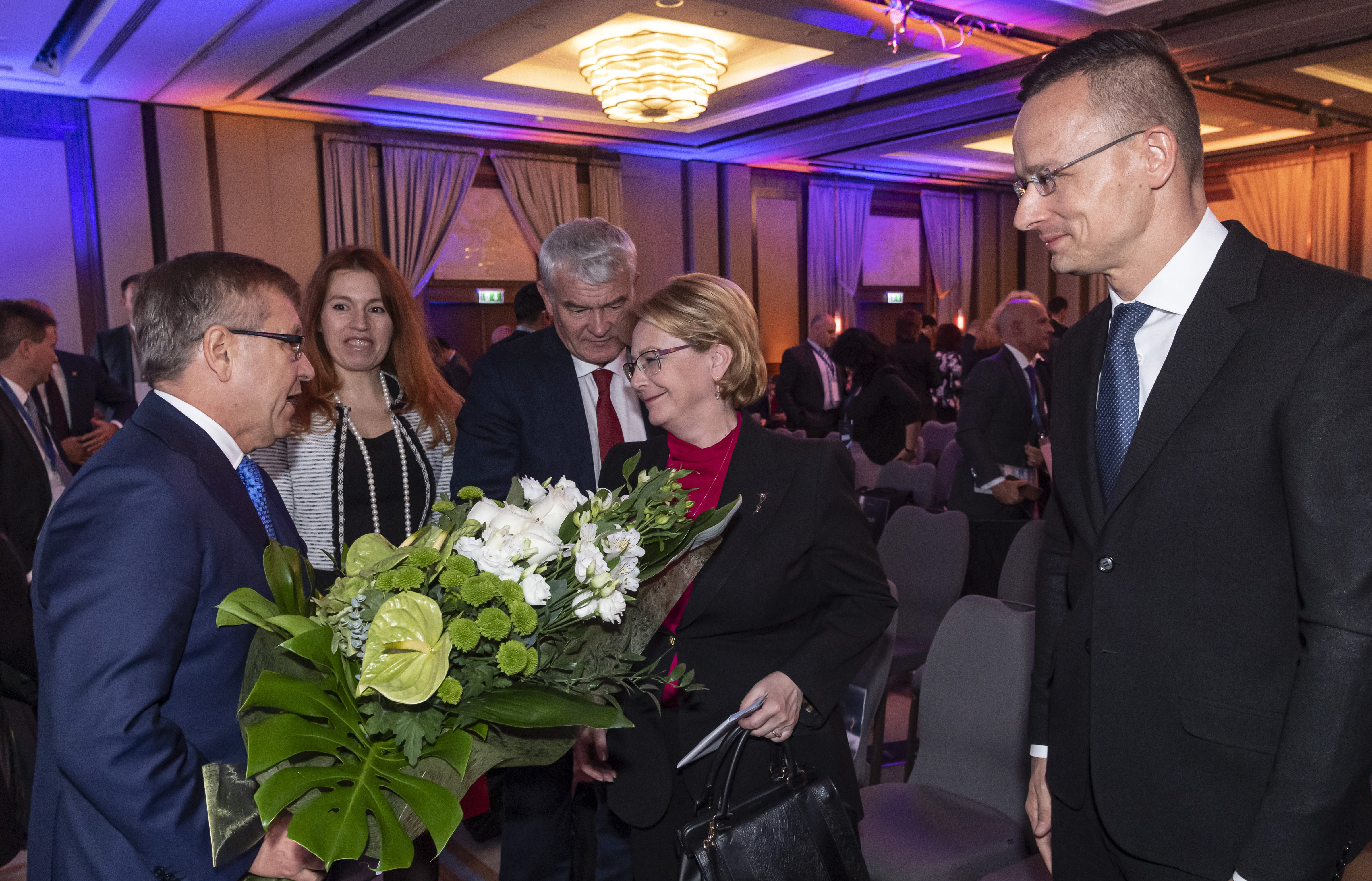 Matolcsy György, az MNB elnöke virágot ad Veronika Szkvorcova orosz egészségügyi miniszternek, mellettük Szijjártó Péter külgazdasági és külügyminiszter a Magyar Nemzeti Bank (MNB) rendezésében tartott Eurázsia Fórumon