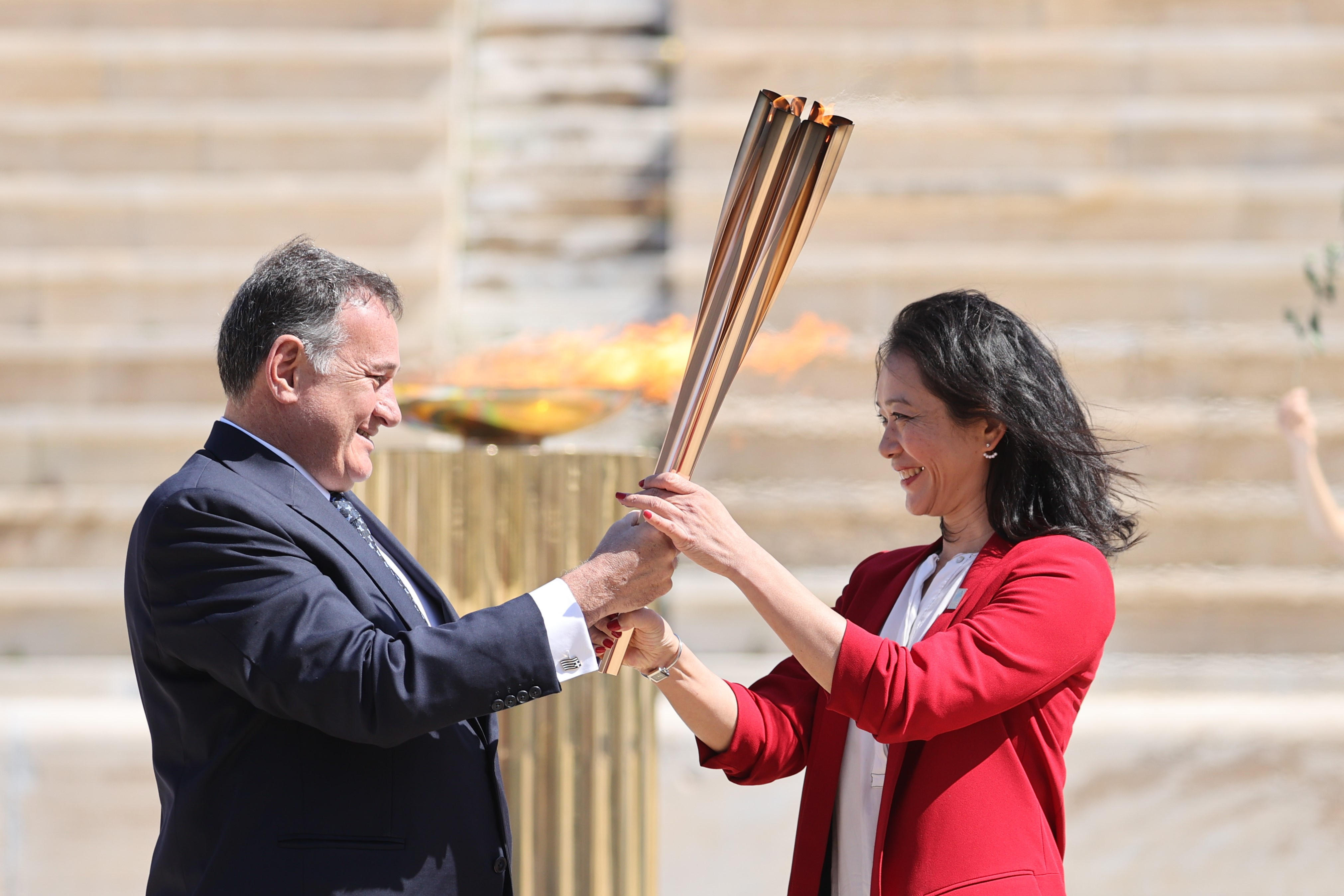 Védőfelszerelés nélkül adta át az olimpiai lángot Görögország Japánnak