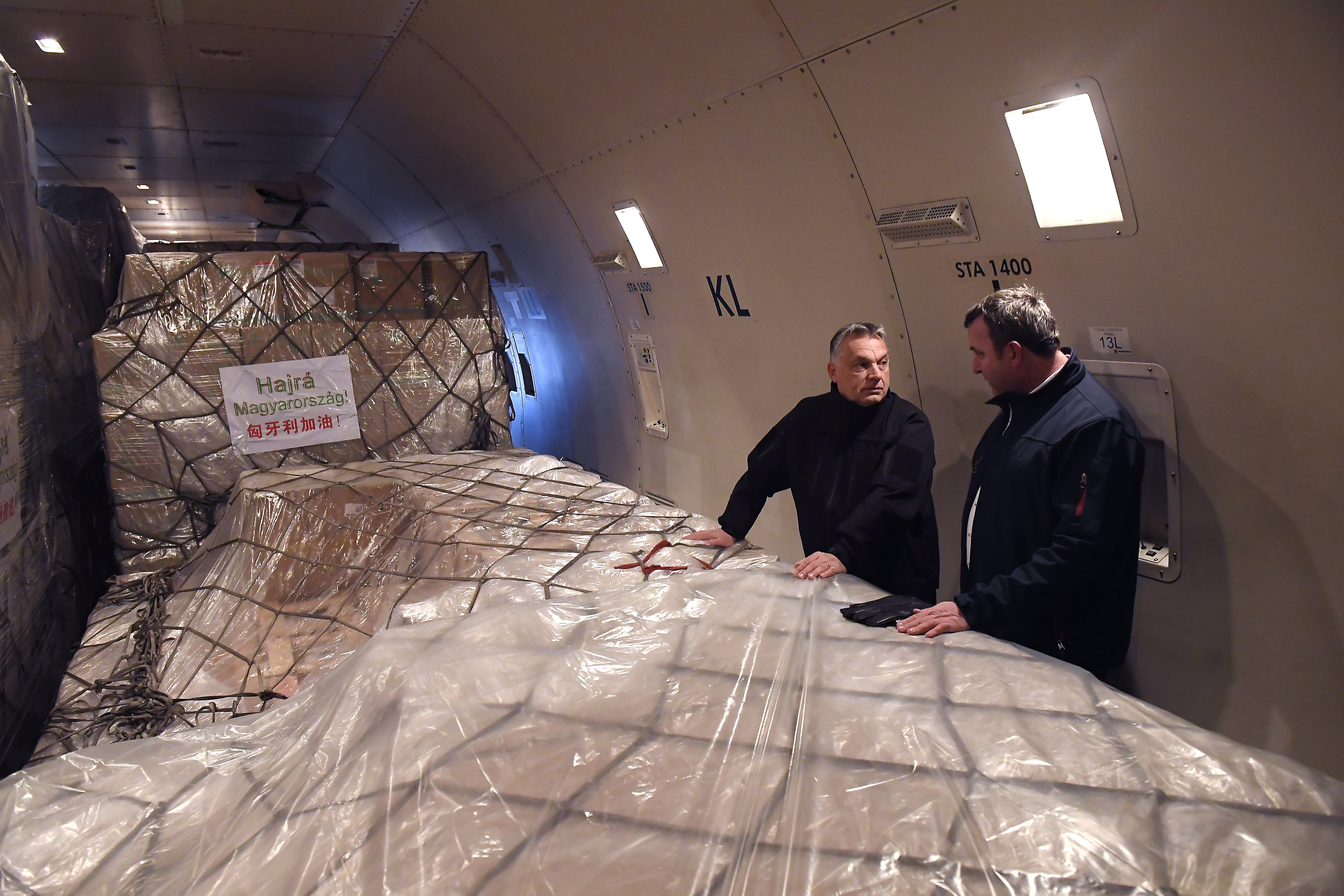 Orbán Viktor és Palkovics László innovációs és technológiai miniszter a Suparna Airlines Kínából érkezett repülõgépének fedélzetén a Liszt Ferenc-repülõtéren 2020. március 24-én. A gép több mint 3 millió maszkot, 100 ezer koronavírus-tesztet és 86 lélegeztetõgépet hozott.