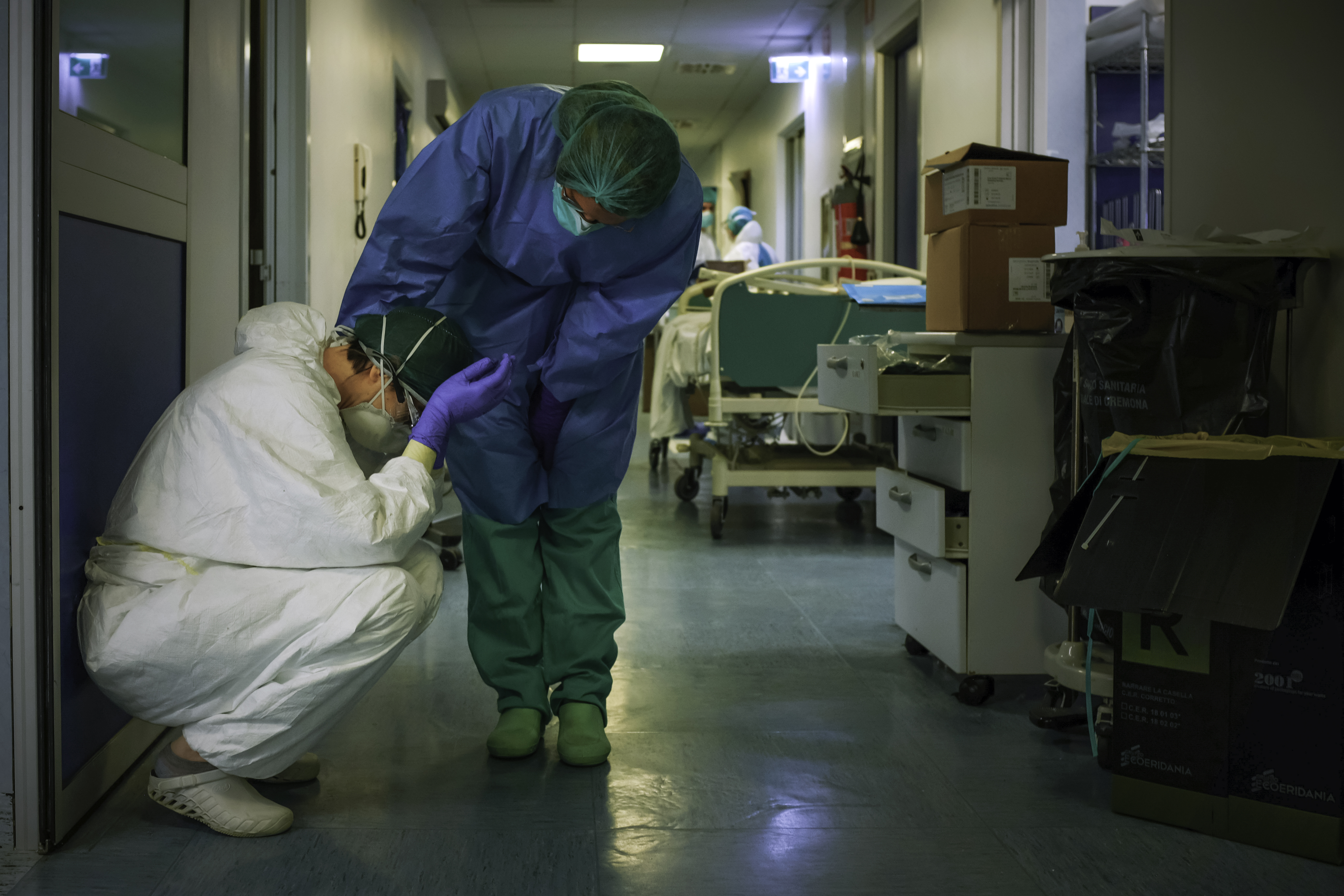 Egy ápoló vigasztalja társát a lombardiai Cremona kórházában műszakváltáskor