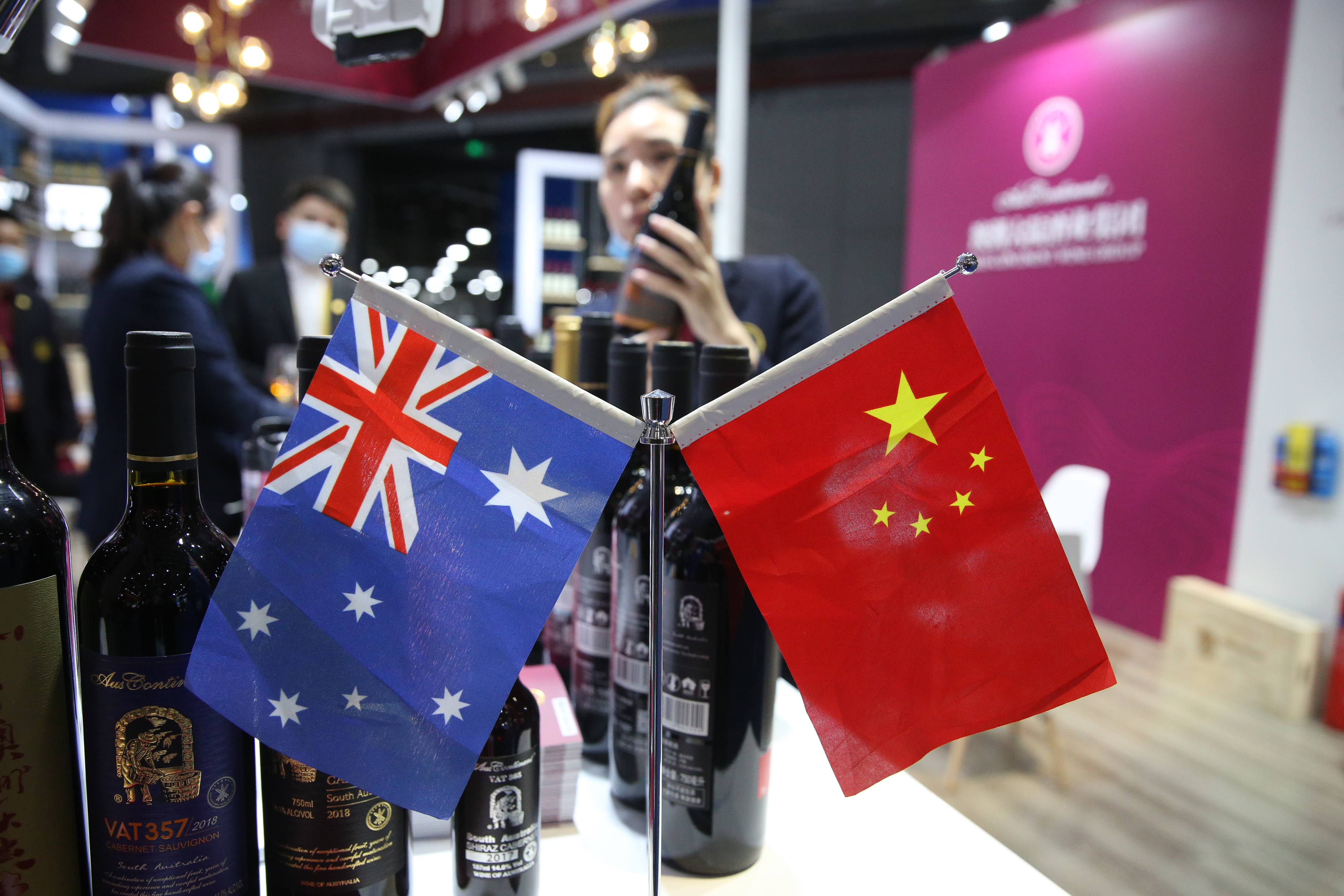Ausztrál és kínai zászlók egy sanghaji kereskedelmi fórumon