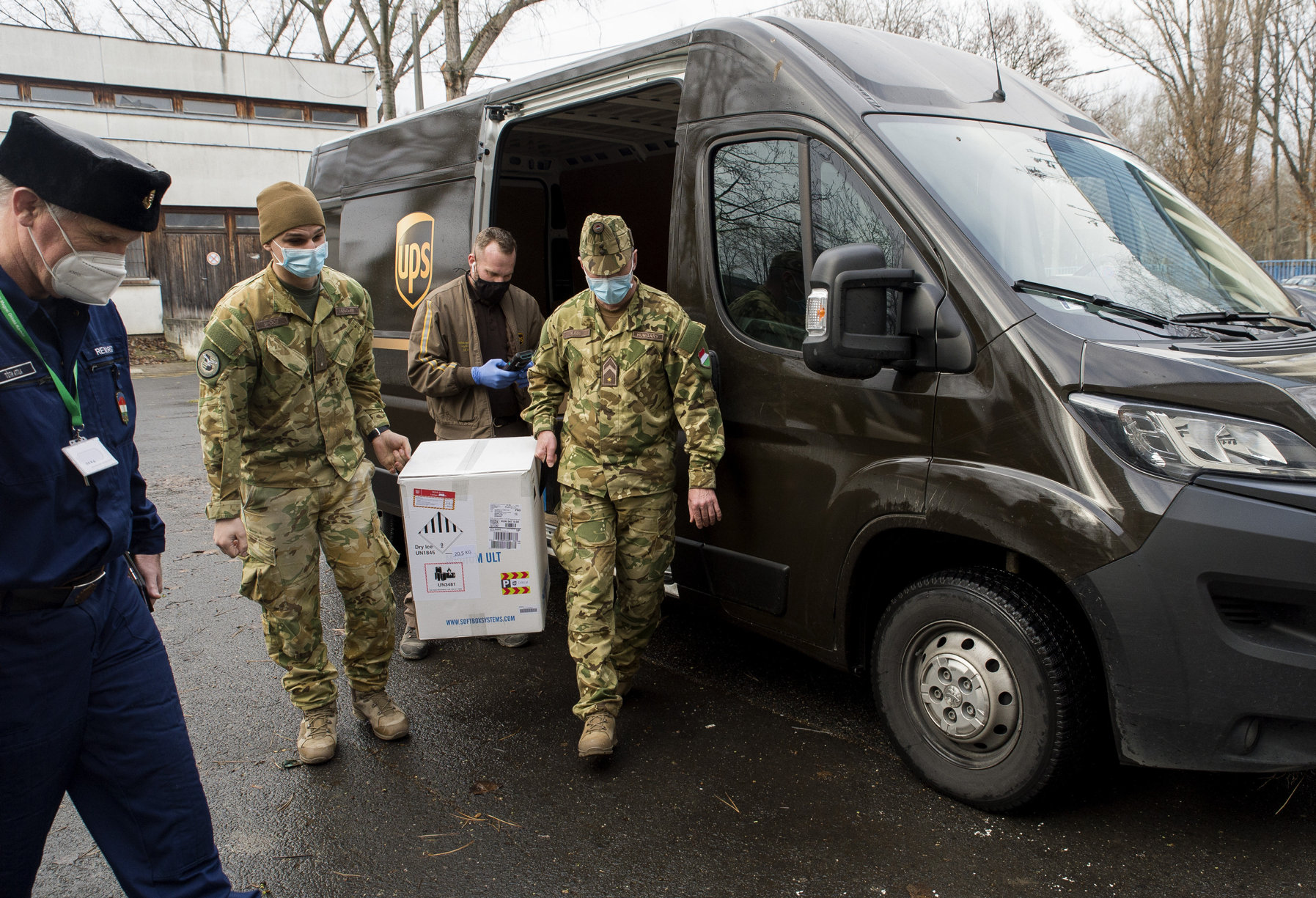 A gyõri Petz Aladár Megyei Oktató kórházba érkezett Pfizer-BioNTech vakcinákat tartalmazó dobozt katonák viszik 2020. december 30-án.