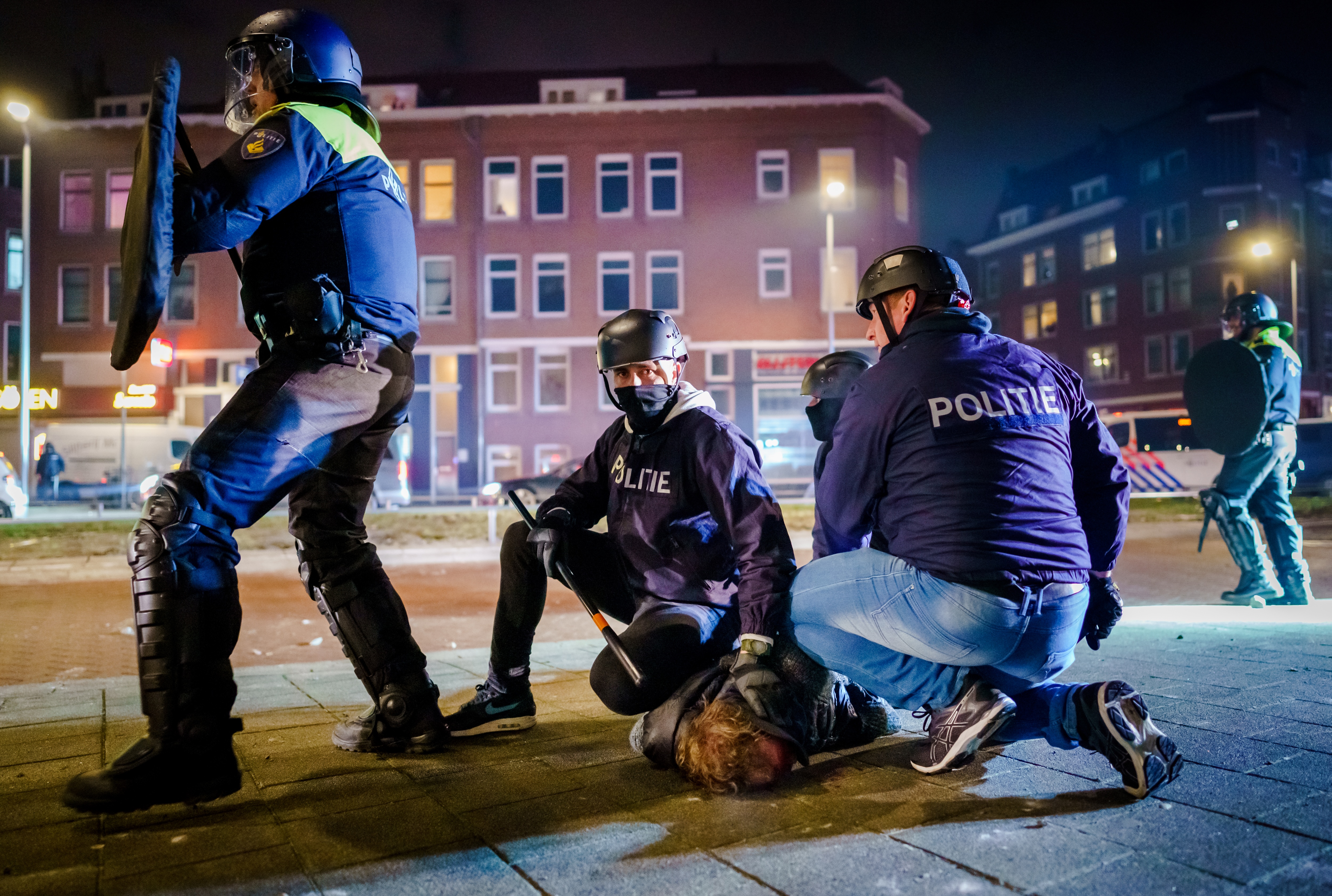 Egy zavargó a rendőrök fogságában Rotterdamban.