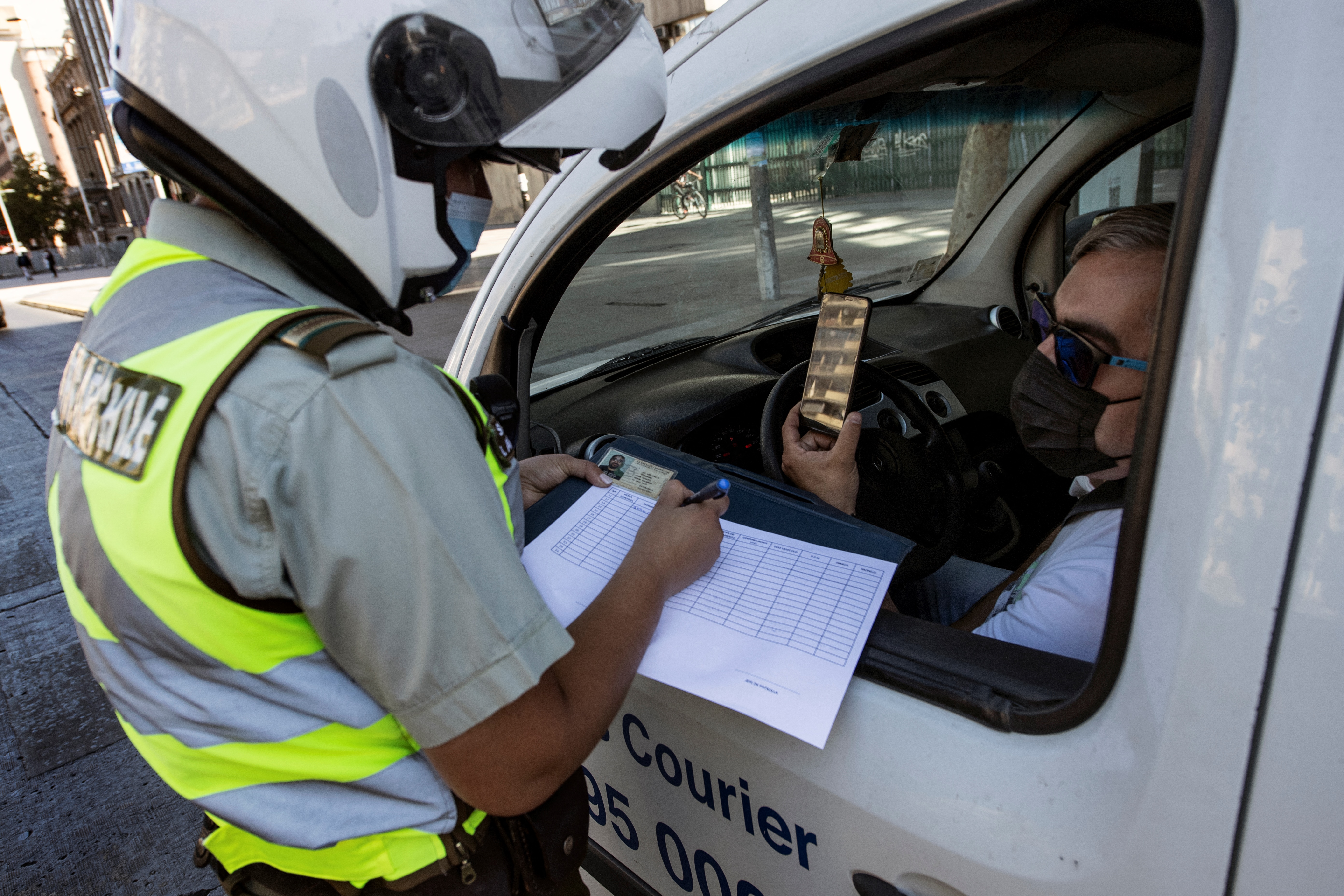 Chilei rendőr ellenőrzi a friss járványügyi szigorítások betartását március 27-én