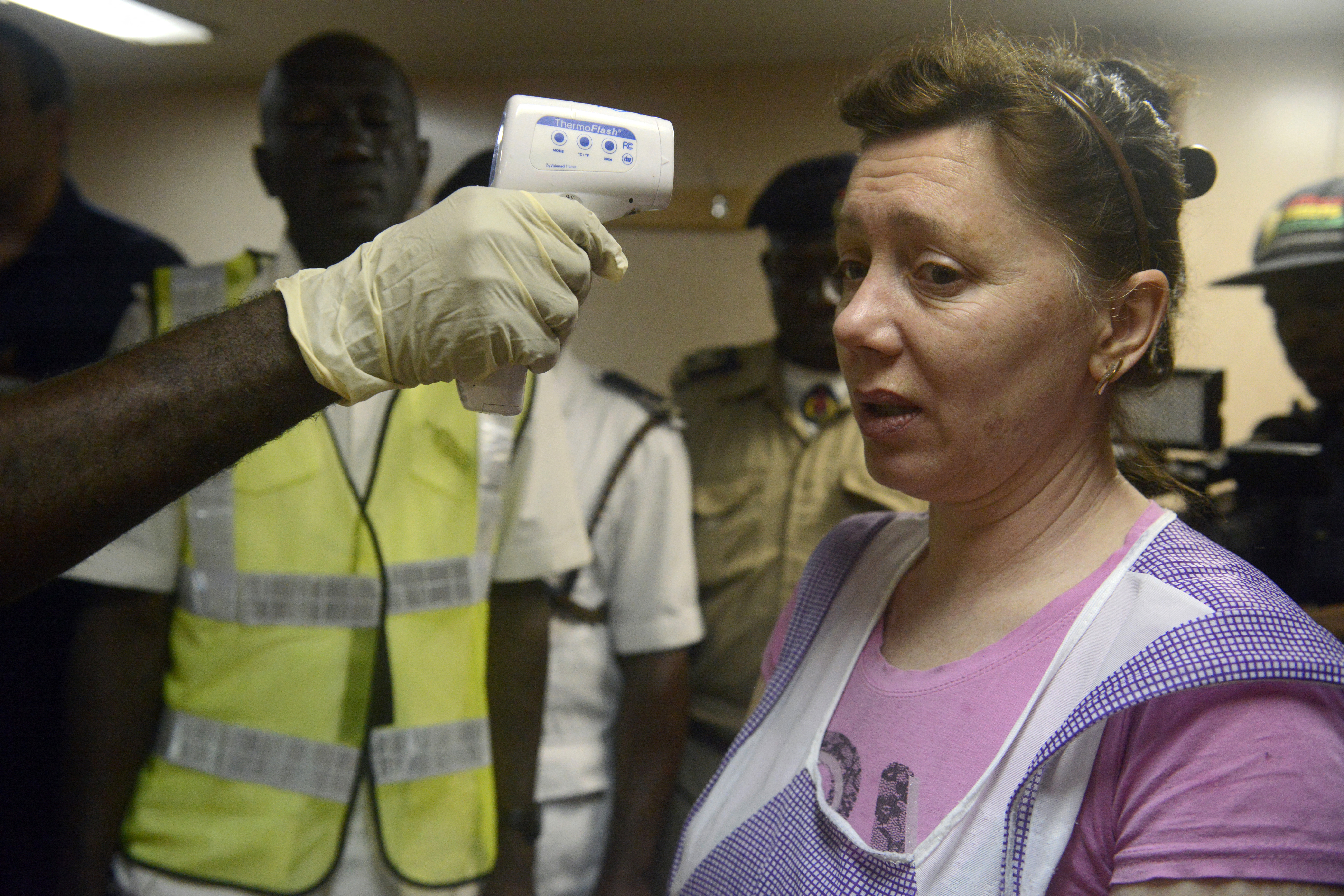 Nigériai egészségügyi dolgozók mérik egy ukrán vendégmunkás testhőmérsékletét az MV Pintail szállítóhajón az egyik lagosi kikötőben 2014. szeptember 29-én.