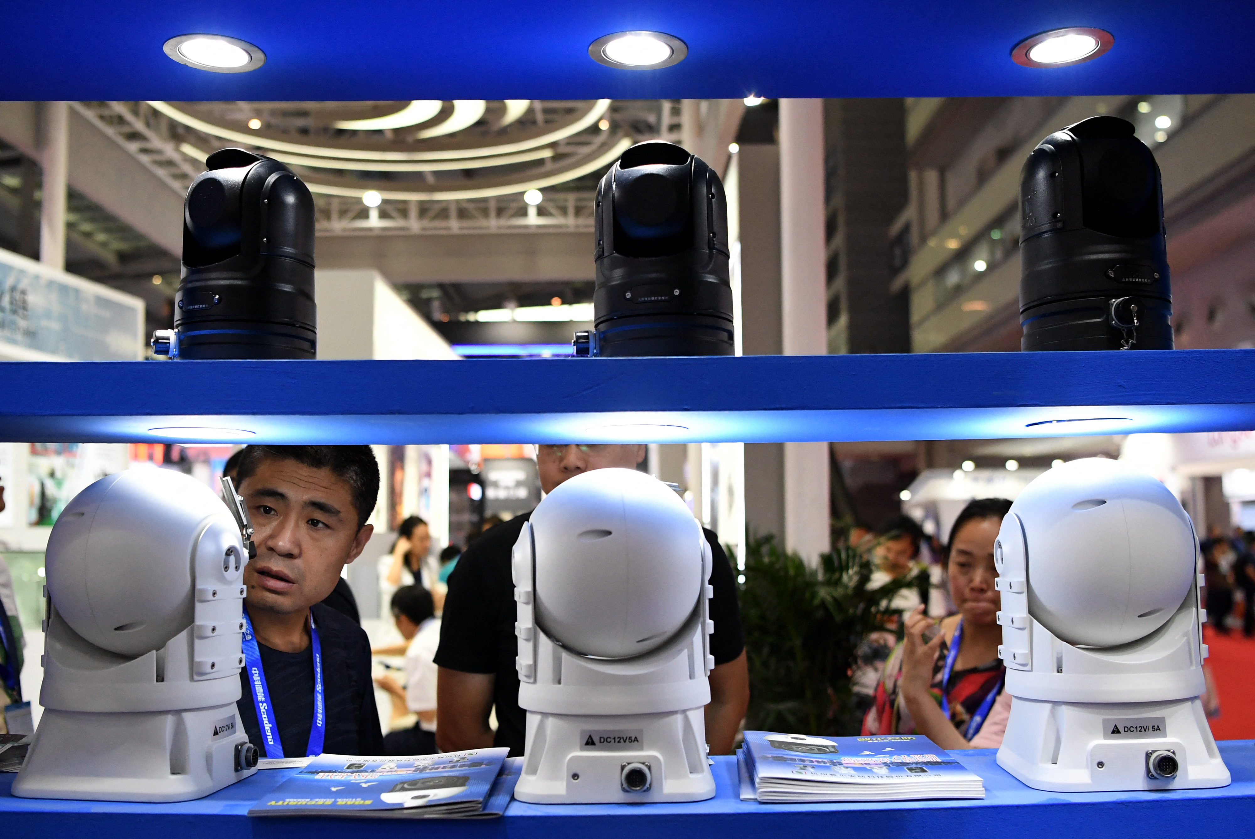 Egy látogató nézegeti a térfigyelő kamerákat egy biztonságtechnológiai kiállításon Sencsenben, 2018 októberében.