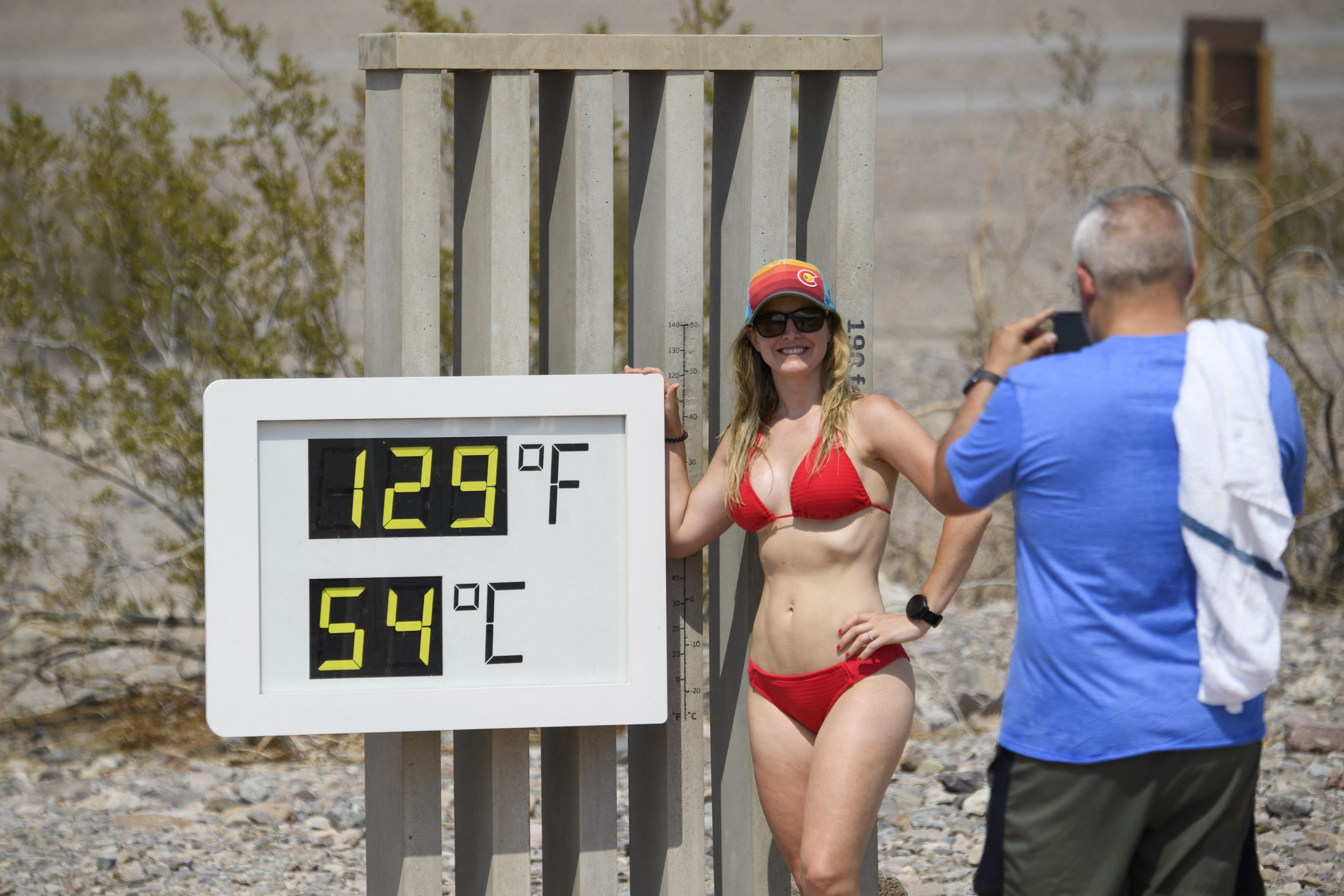 Pózoló turista a kaliforniai Death Valley Nemzeti Park látogatóközpontjánál 2021. június 17-én