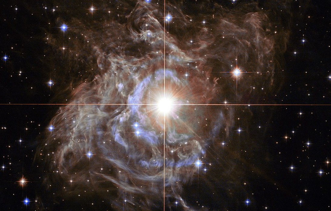 Az egyik legszebb kozmikus világítótorony, az RS Puppis nevű csillag. A csillag 40 napos periódussal halványodik-fényesedik, a fényes fázis kék fénye pedig a körülötte lévő poron táguló gyűrűkben szóródik felénk.