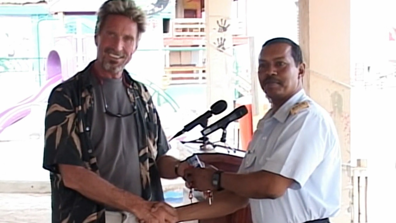 John McAfee és a belize-i rendőrség képviselője az adományozást övező sajtóeseményen