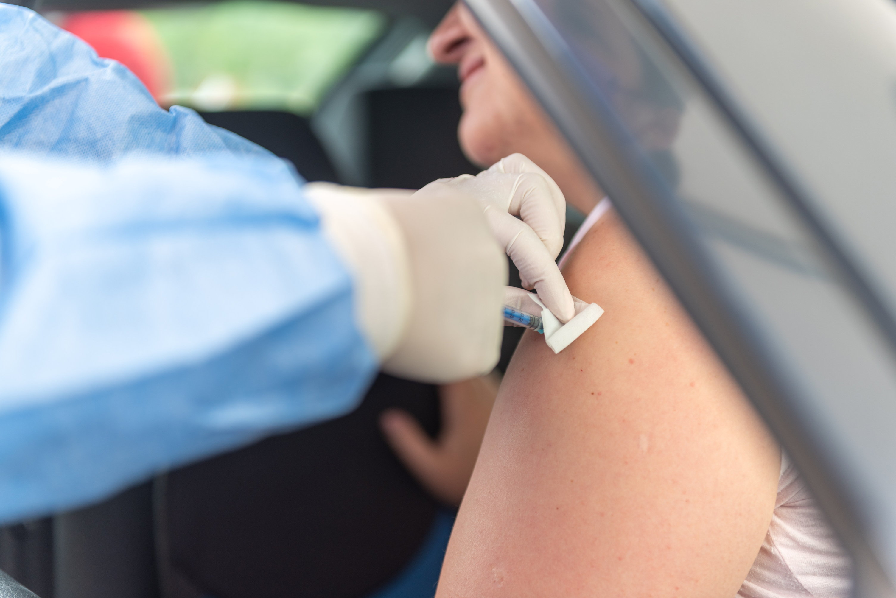 Egy férfi autójában ülve megkapja a Pfizer-BionTech koronavírus elleni Comirnaty-vakcina első adagját a kolozsvári autós oltópontnál.
