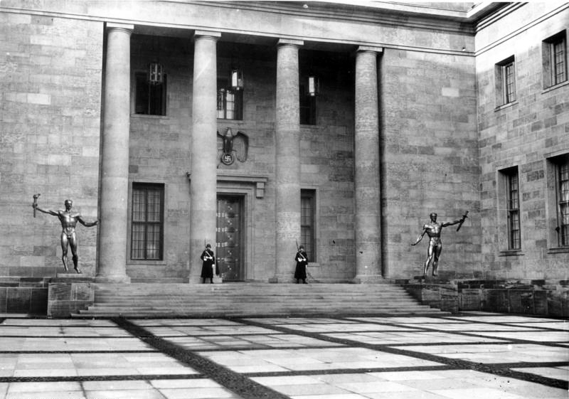 Hitler Új Birodalmi Kancelláriájának egyik udvara (A Becsület Udvara) egy 1939-es fotón. A lépcső jobb oldalán a Die Wehrmacht jobbra pedig a Die Partei című szobrok Arno Breker alkotásai.