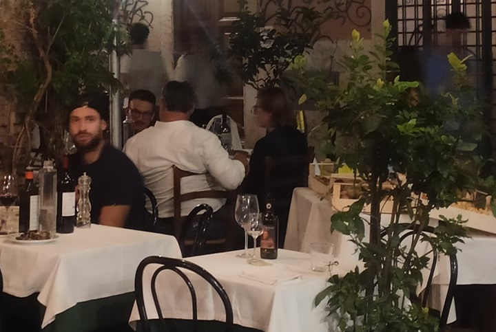 Orbán Viktor kormányfő háttal, fehér ingben, jobbra tőle Lévai Anikó, vele szemben pedig Orbán Gáspár honvédtiszt csütörtök este egy római étteremben 2021. augusztus 26-án.