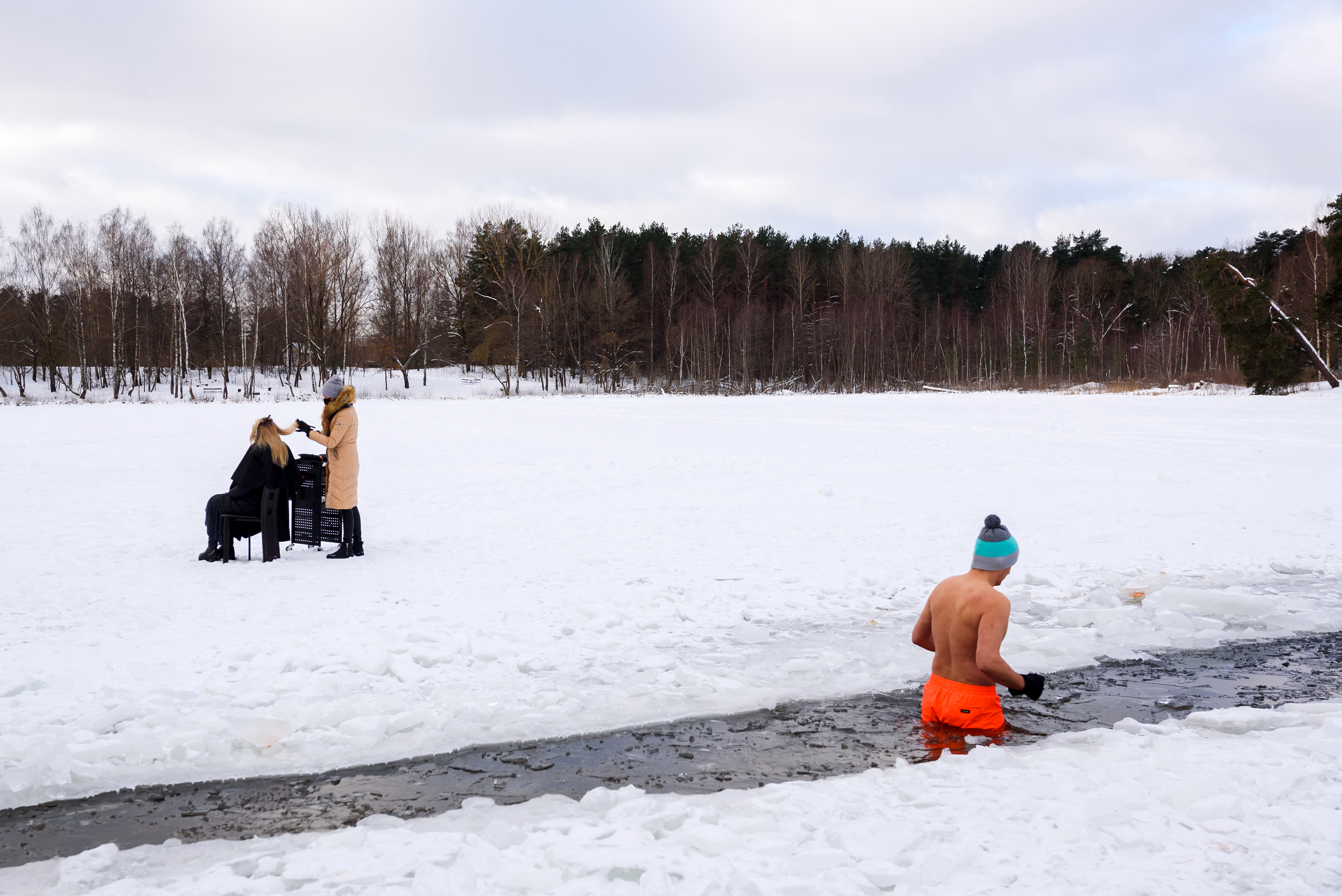 A fodrászoknak is be kell zárniuk, mint egy éve ilyenkor, amikor ez a fotó készült a Babelitis tó partján, amikor ezt a narancssárga nadrágos úszót nem zavarta a befagyott tó jegén maszekoló szépségipari szolgáltató.