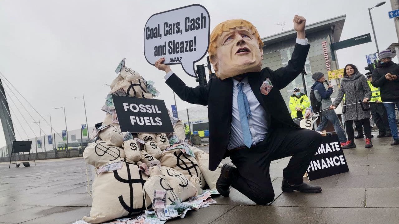 Szén, autók, készpénz és korrupció – tüntető klímaaktivista a COP26-on Glasgow-ban, 2021. november 13-án.