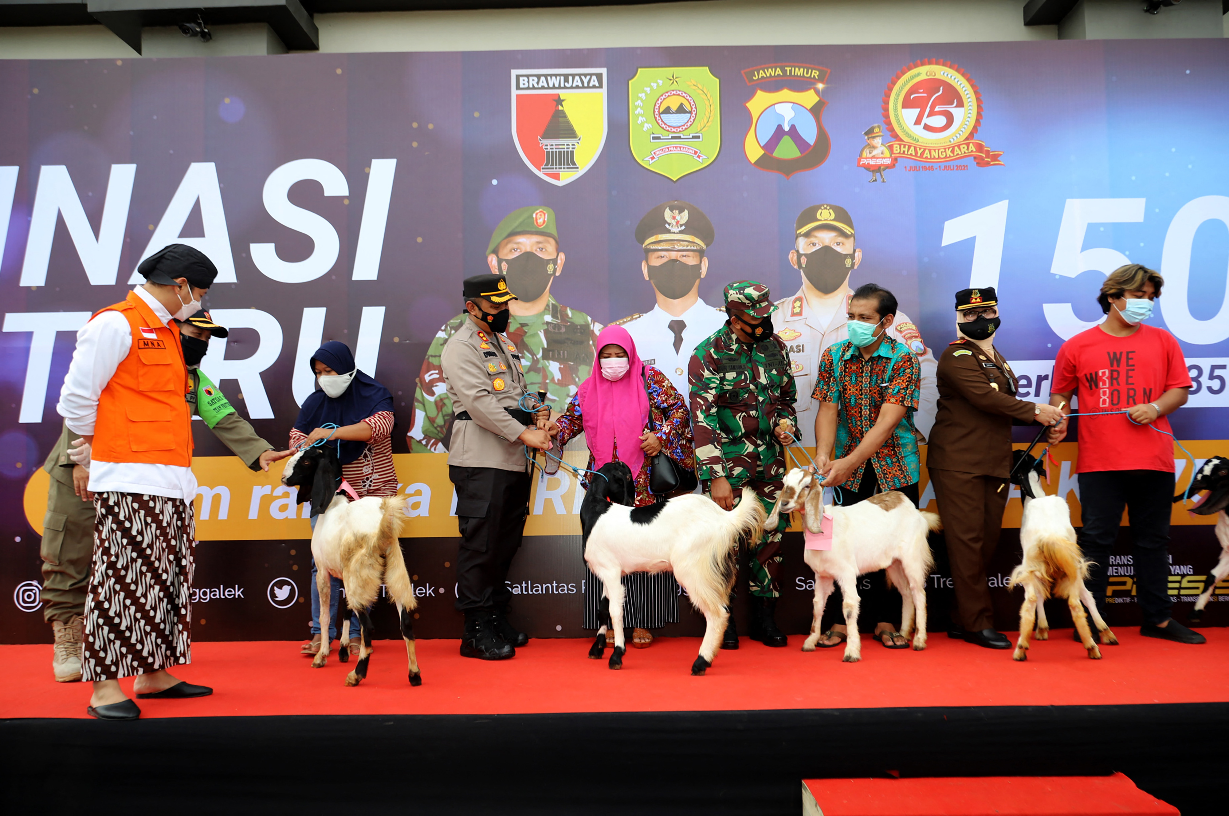 A vakcinalottó boldog nyertesei az indonéziai Kelet-Jáva tartományban 2021. június 23-án, az oltottak között kecskéket és csirkéket sorsoltak ki.