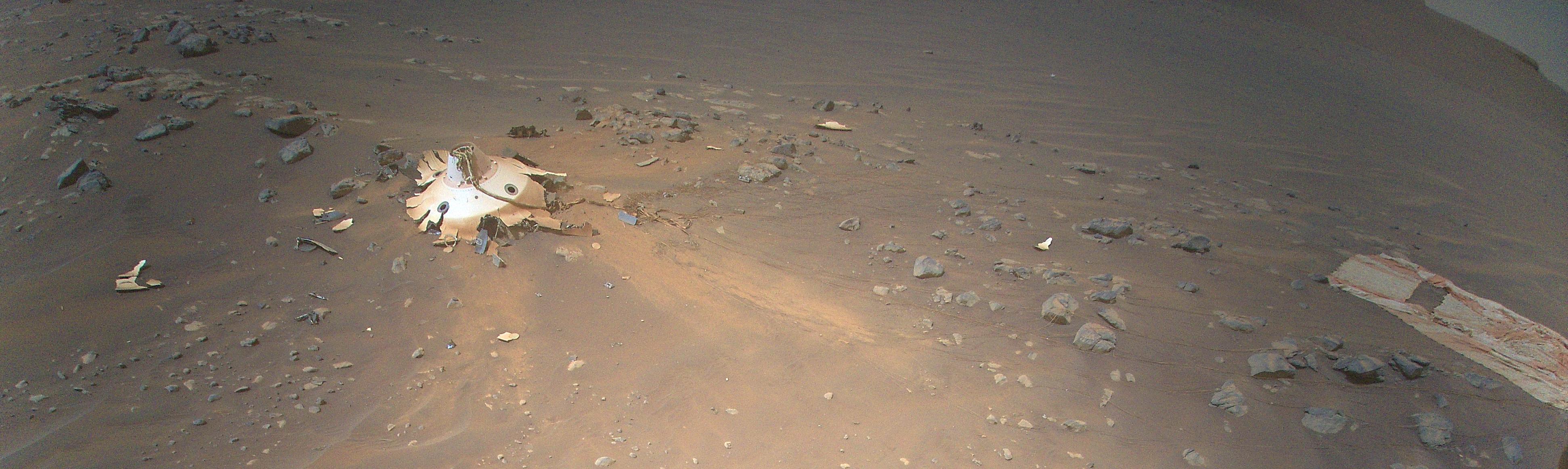 A Perseverancet és az Ingenuityt Marsra szállító kapszula hátuljának (bal oldalt) maradványai és a szuperszonikus ejtőernyő (jobb oldalt) a Mars-helikopter panorámafelvételén