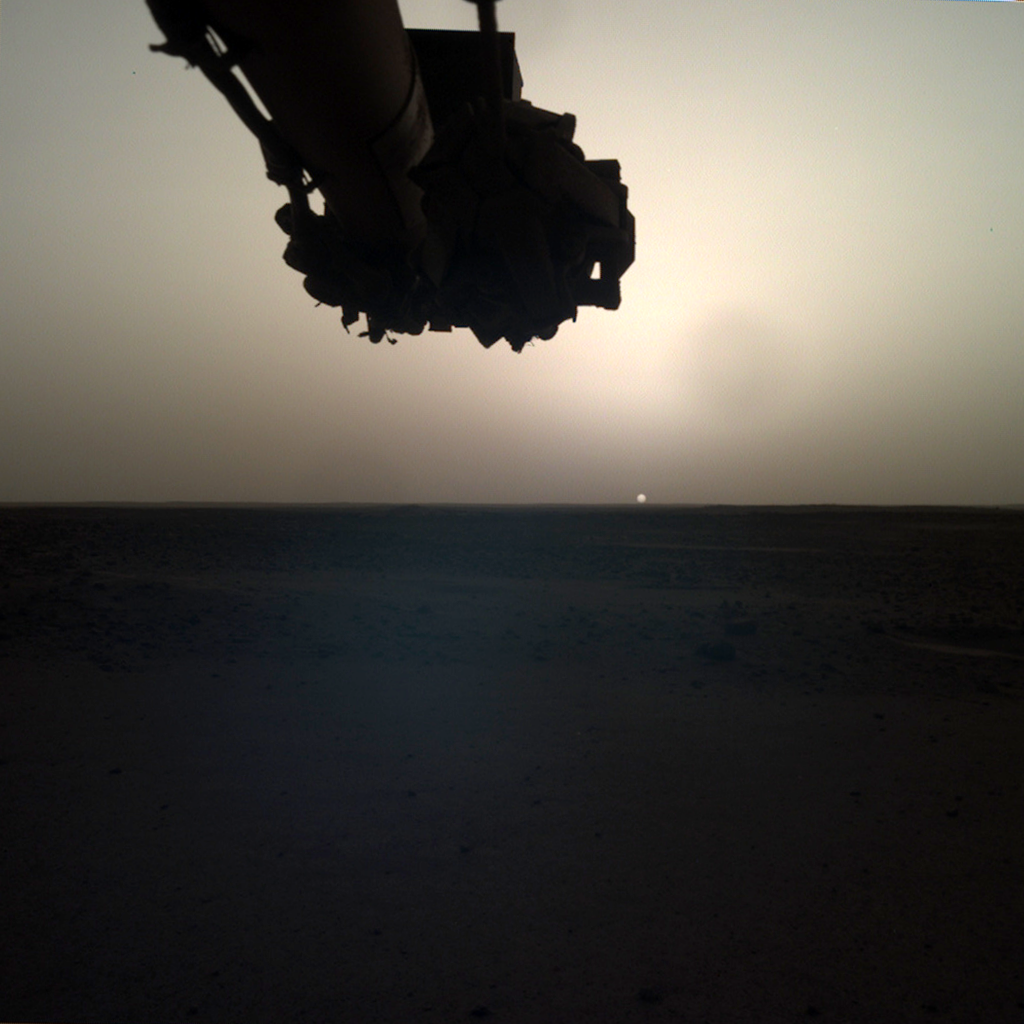 Napfelkelte a Marson egy április eleji felvételen. Fent az InSight robotkarja látható, amivel a felszínre helyezte a szeizmográfot
