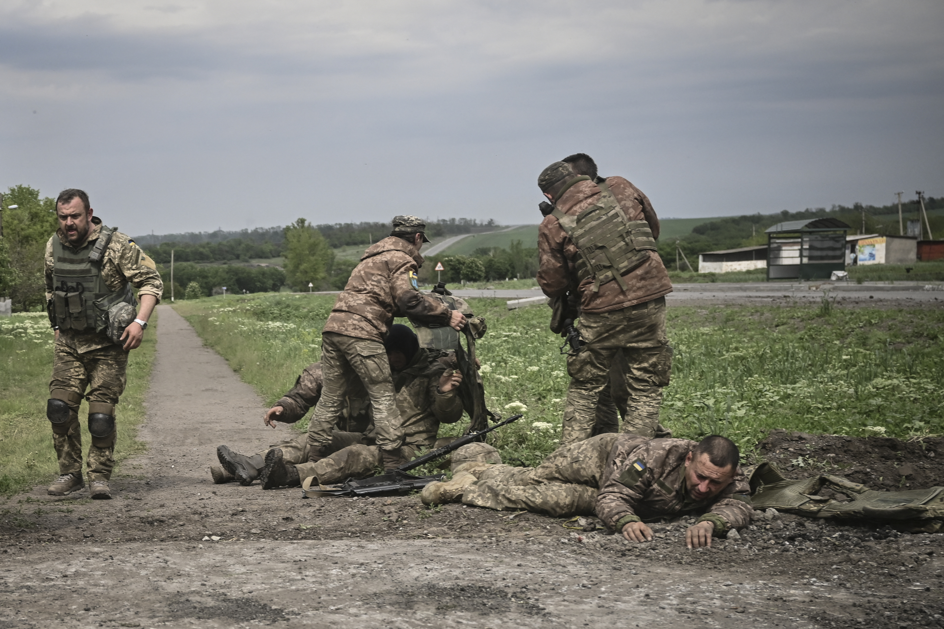 Ukrán katonák segítik a sérült társaikat a donbászi fronton.