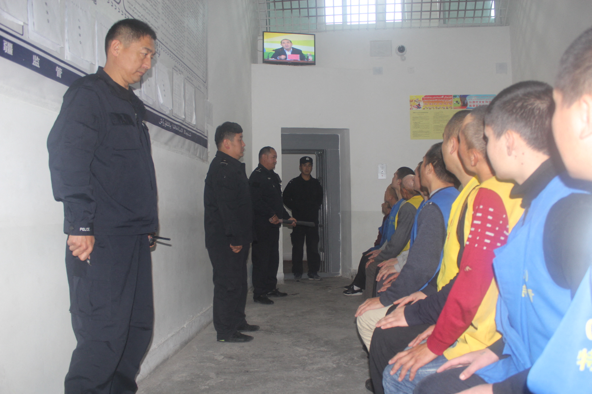 A rendőrök Ili prefektúra akkori kormányzójának, Nurlan Abdumalinnak a tévébeszédét nézetik a fogvatartottakkal a Tekes megyei fogolytáborban a nyugat-kínai Hszincsiang tartományban.